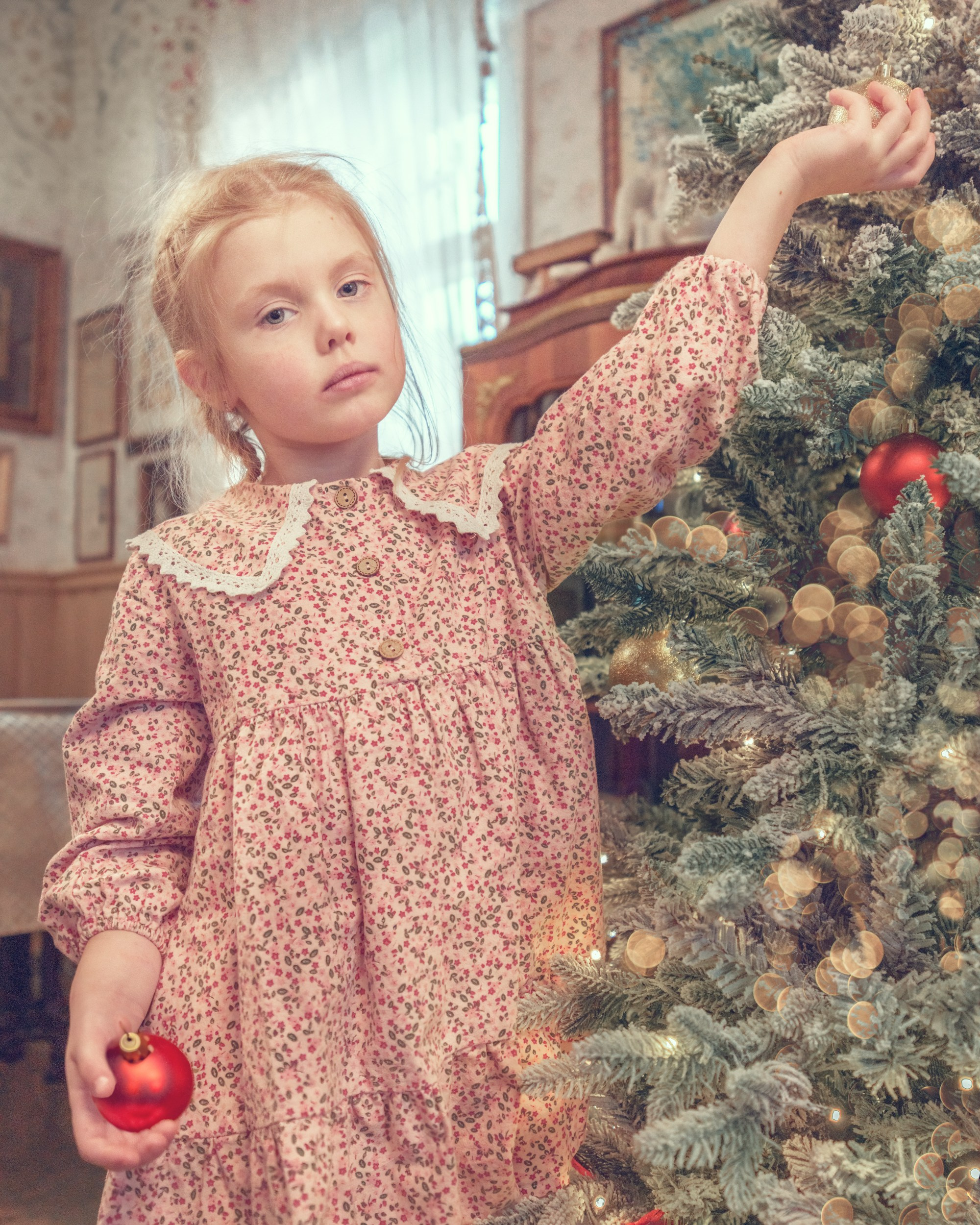 Машенька в рождественском наряде наряжает елку