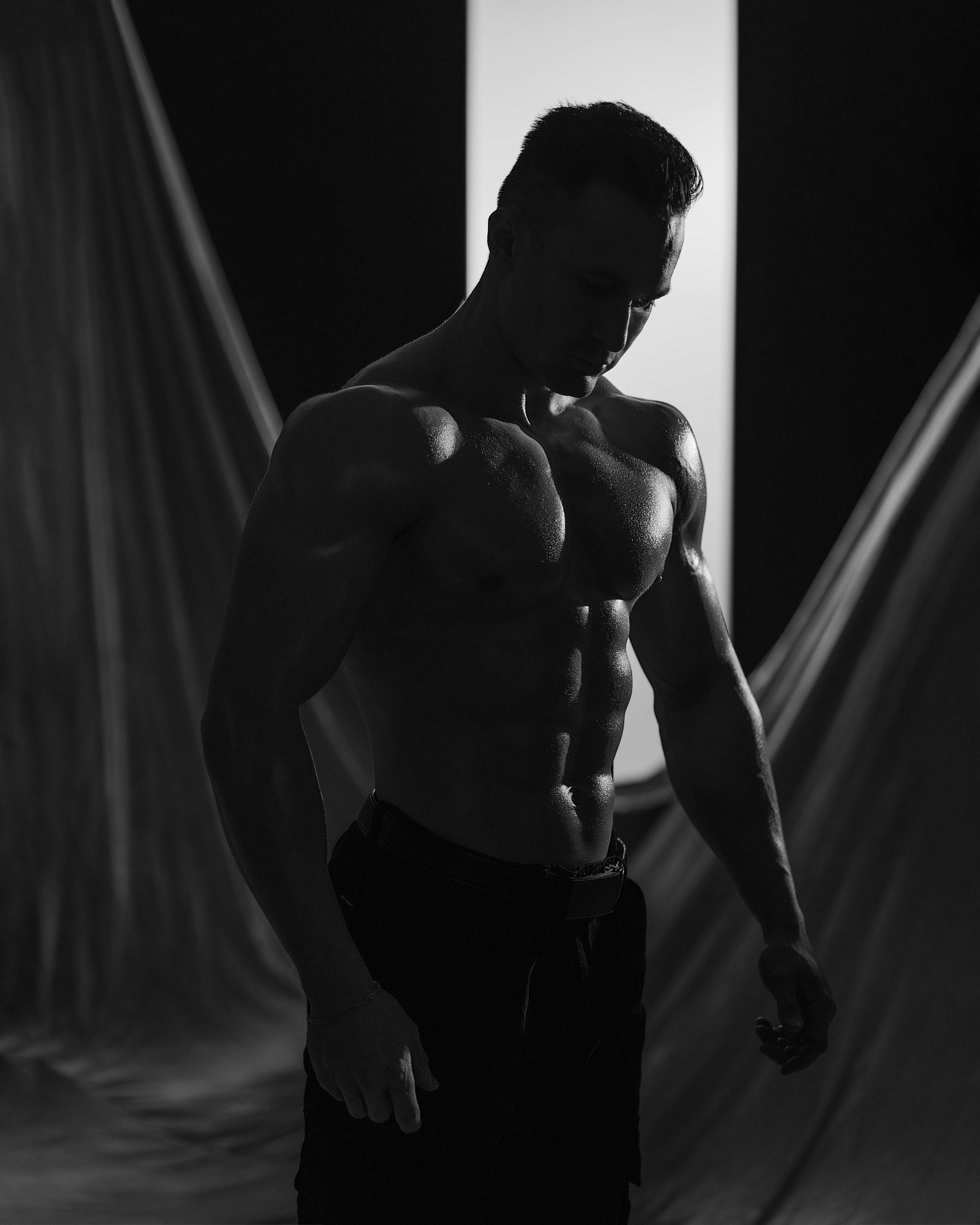 Мужское черно-белое фото в темном ключе, бодибилдер, жесткий свет