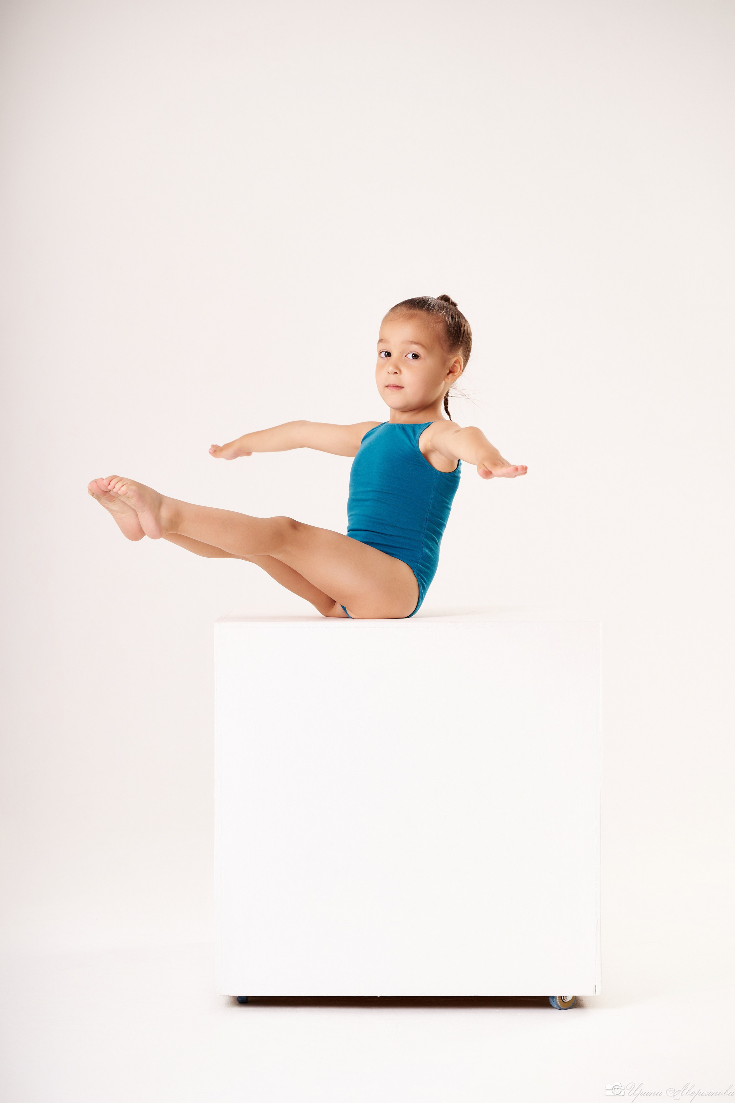гимнастка малышка на белом кубе