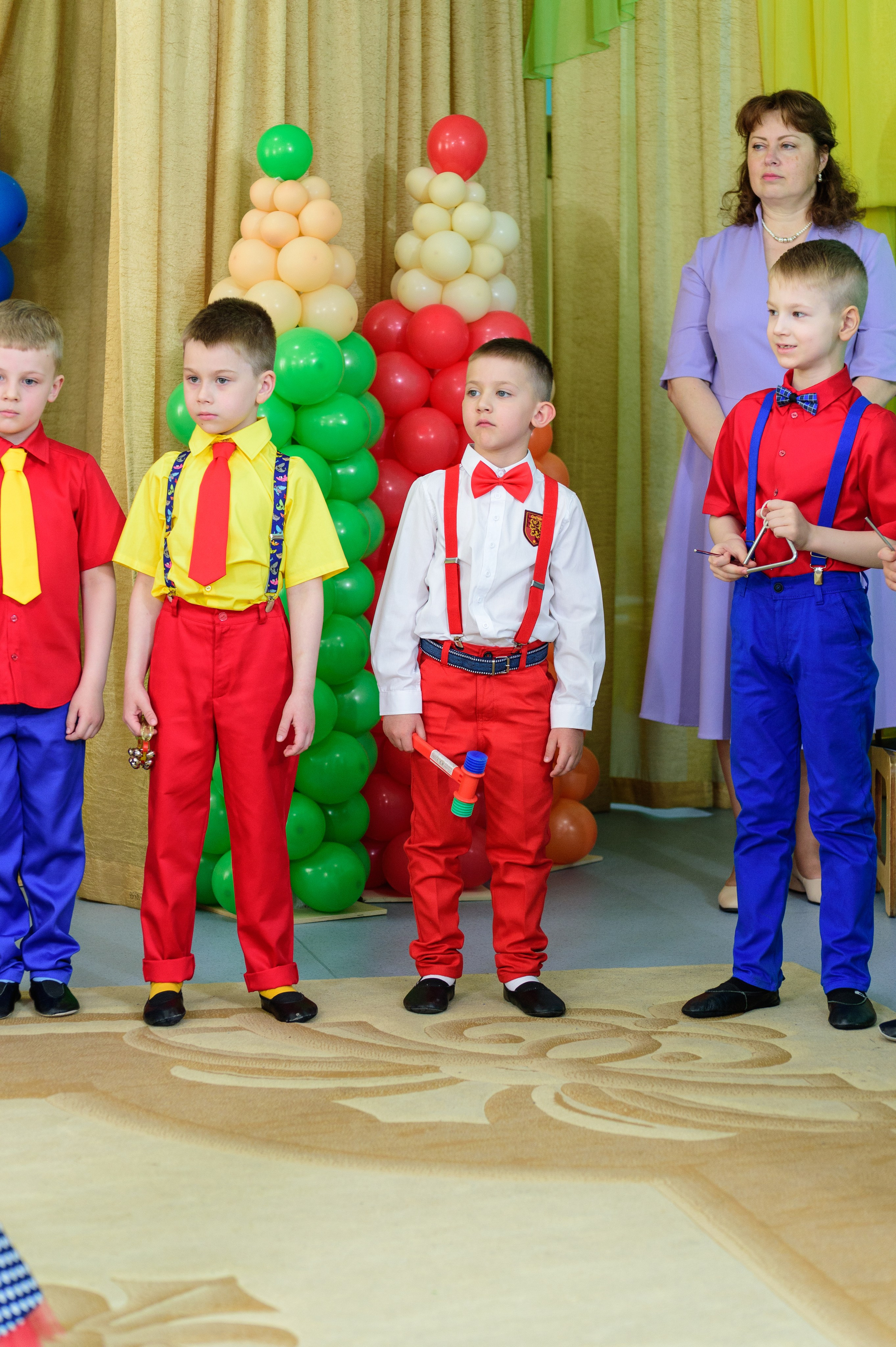 Три мальчика стоят в костюмах стиляг на выпускном.