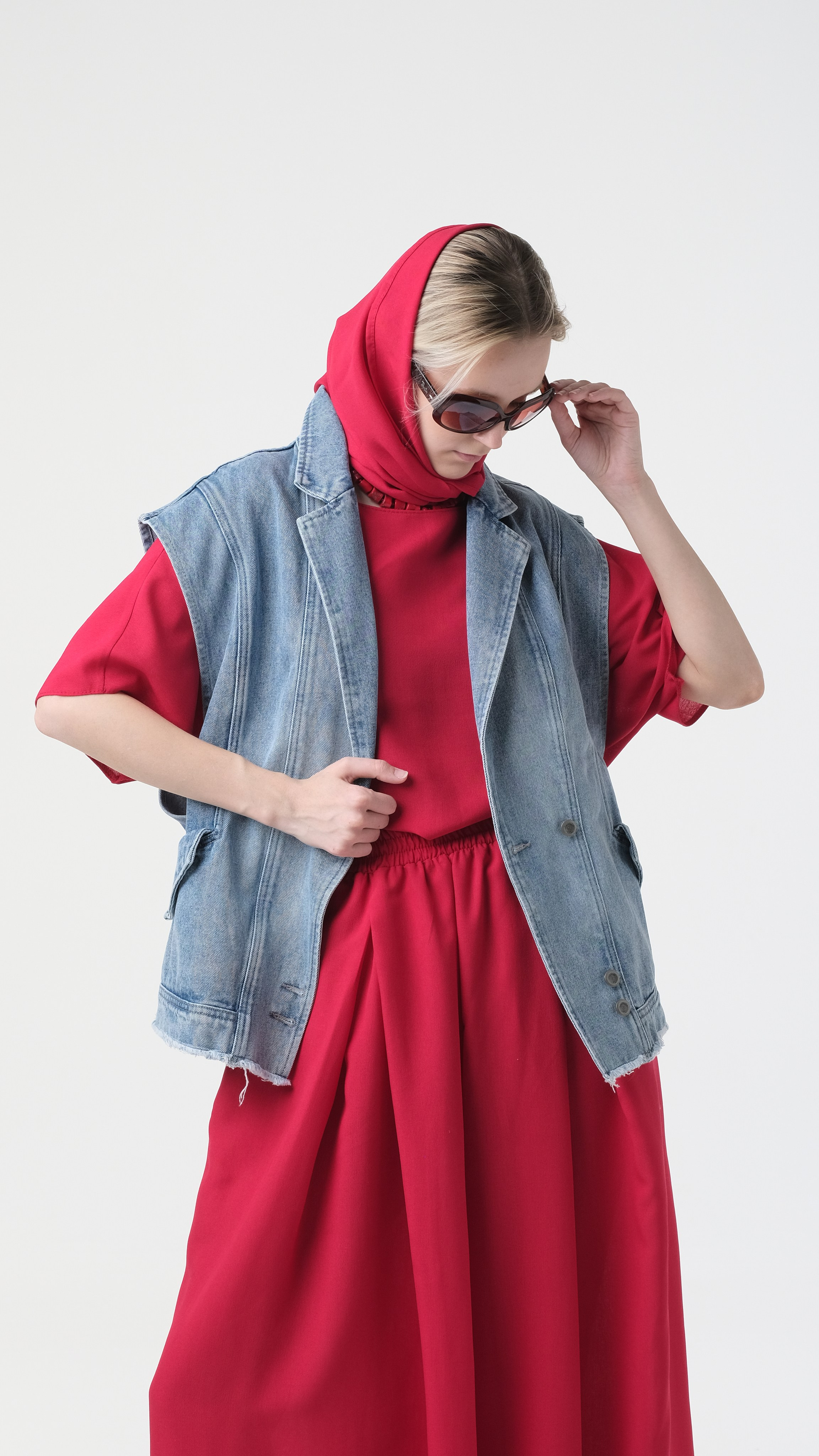 Портрет средним планом на циклораме. Фото на светлом фоне. Сочетание несочетаемого - красный костюм, с джинсовой безрукавкой. На голове красный платок и солнечные очки.