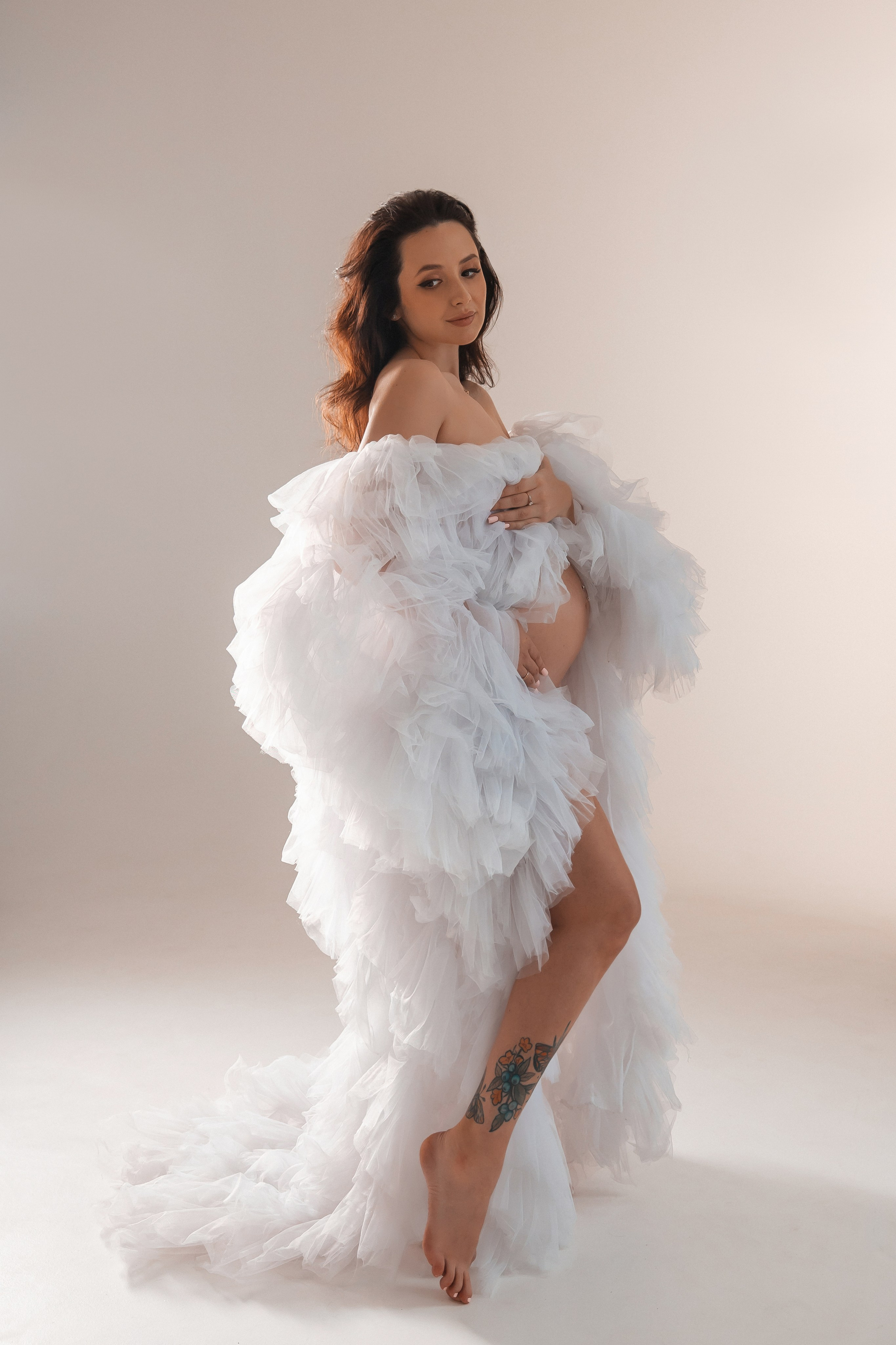 Беременная фотосессия в белой накидке на циклораме