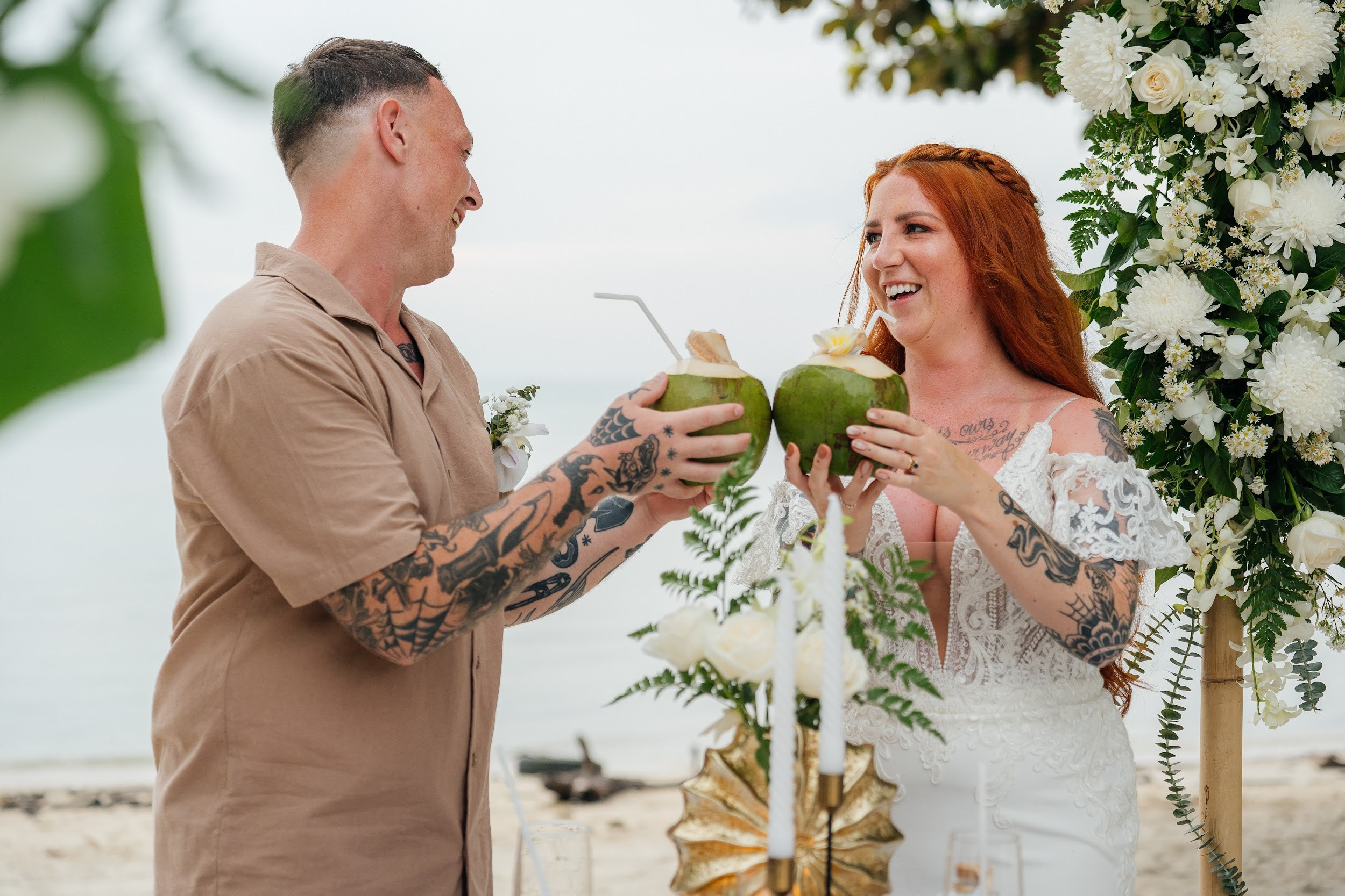 Romantic destination wedding on Koh Samui beach with tropical flowers, ocean views and happy newlyweds