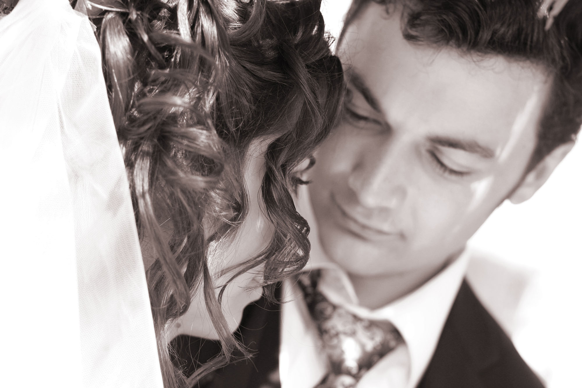 Крупный черно-белый портрет жениха и невесты с темными волосами.