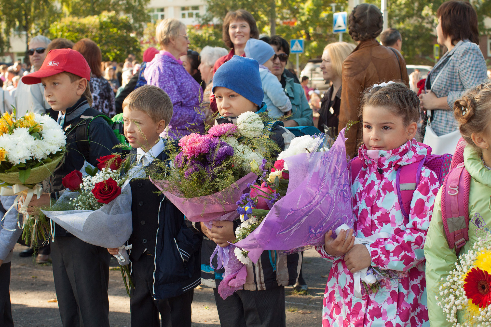 Дети с букетами цветов стоят на улице