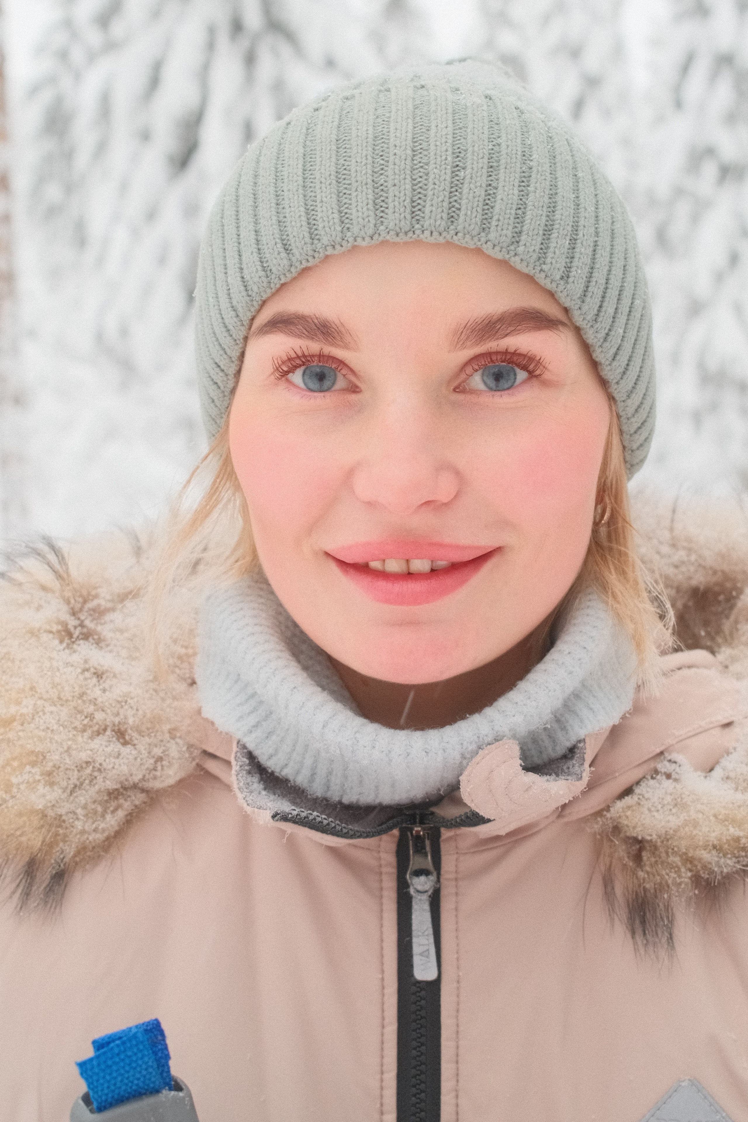 Портрет девушки в вязаной шапке в зимнем лесу