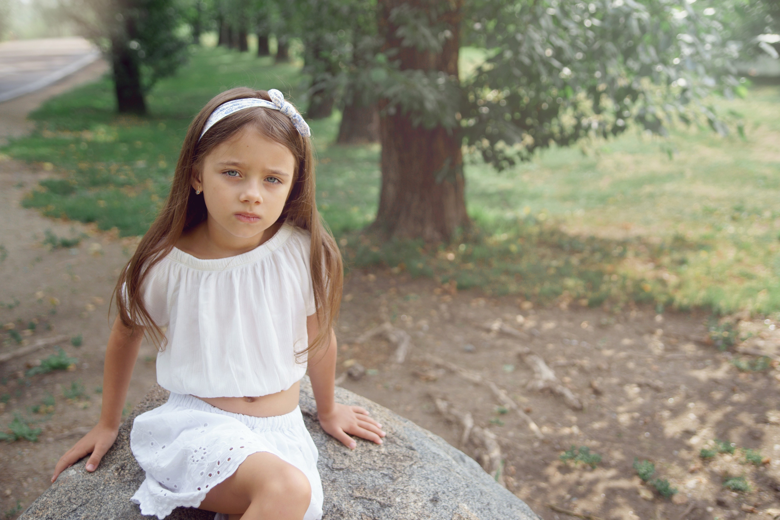 Детская фотосессия летом - девочка сидя на камне