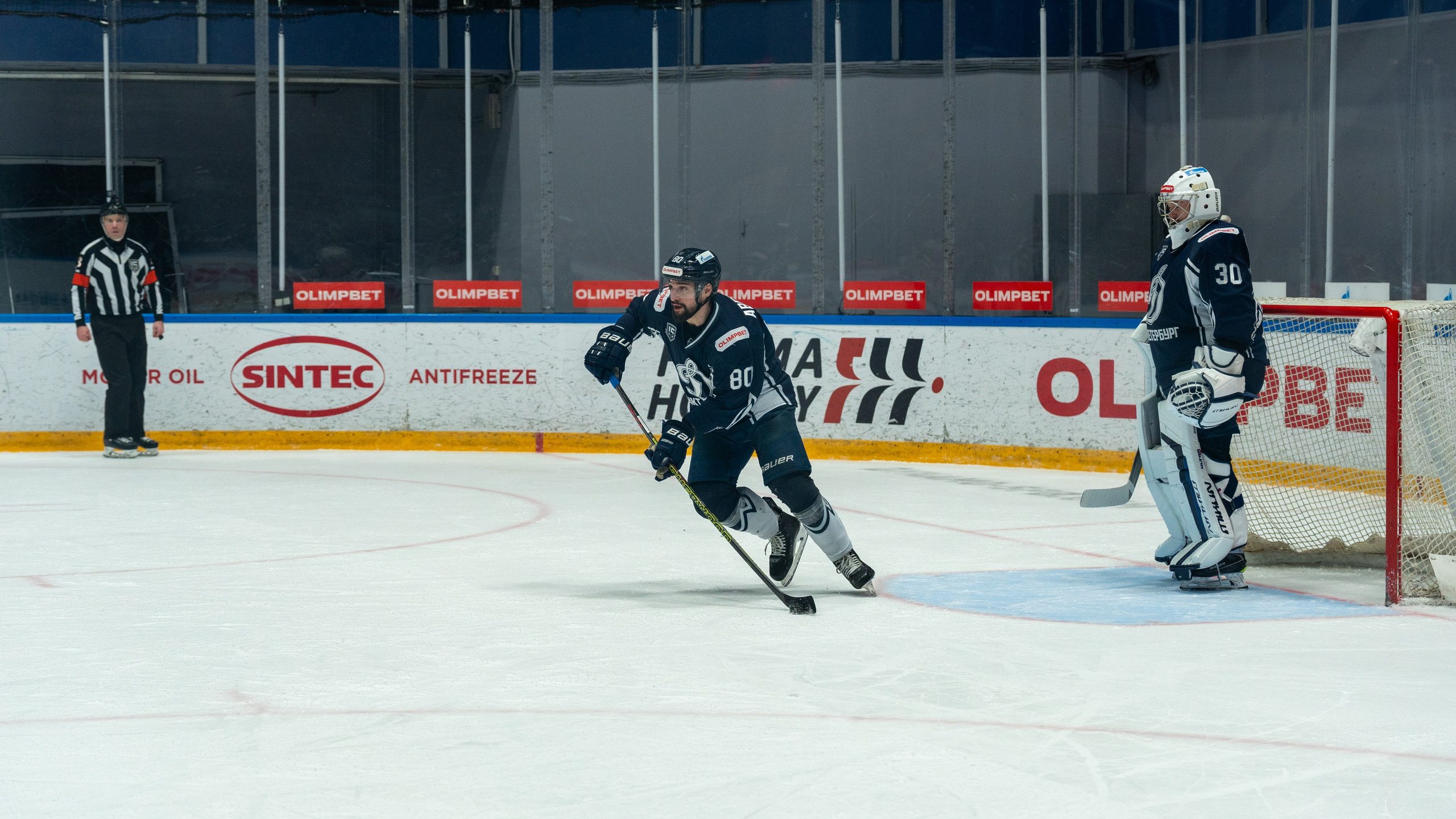 Игрок «Динамо» начинает атаку из своей зоны, вратарь наблюдает. Репортажная спортивная фотосъёмка, динамика, Санкт-Петербург.