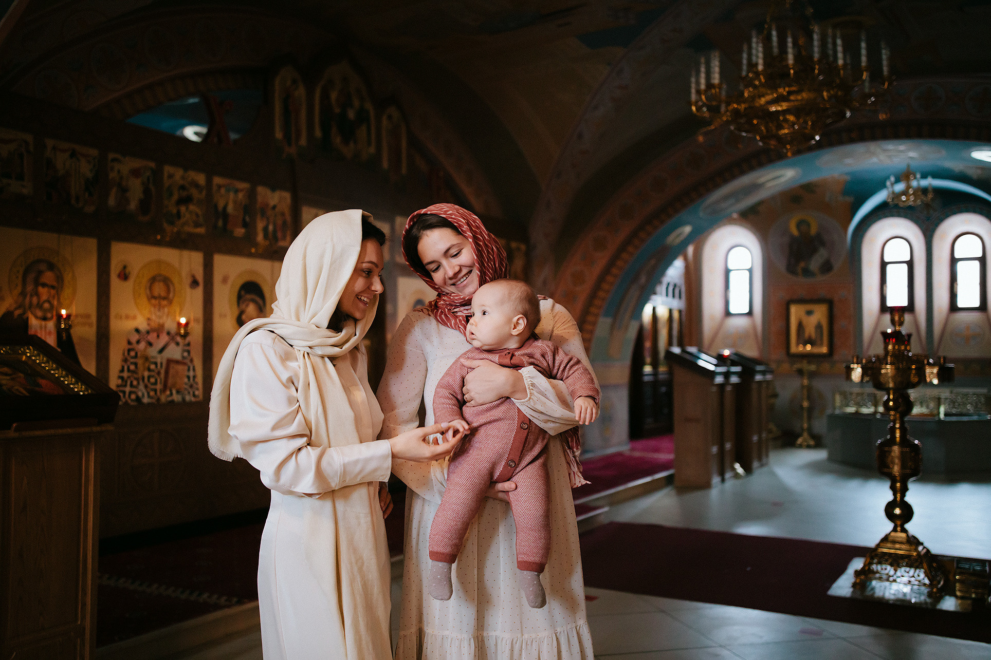 Крёстные и ребенок в храме на крещении