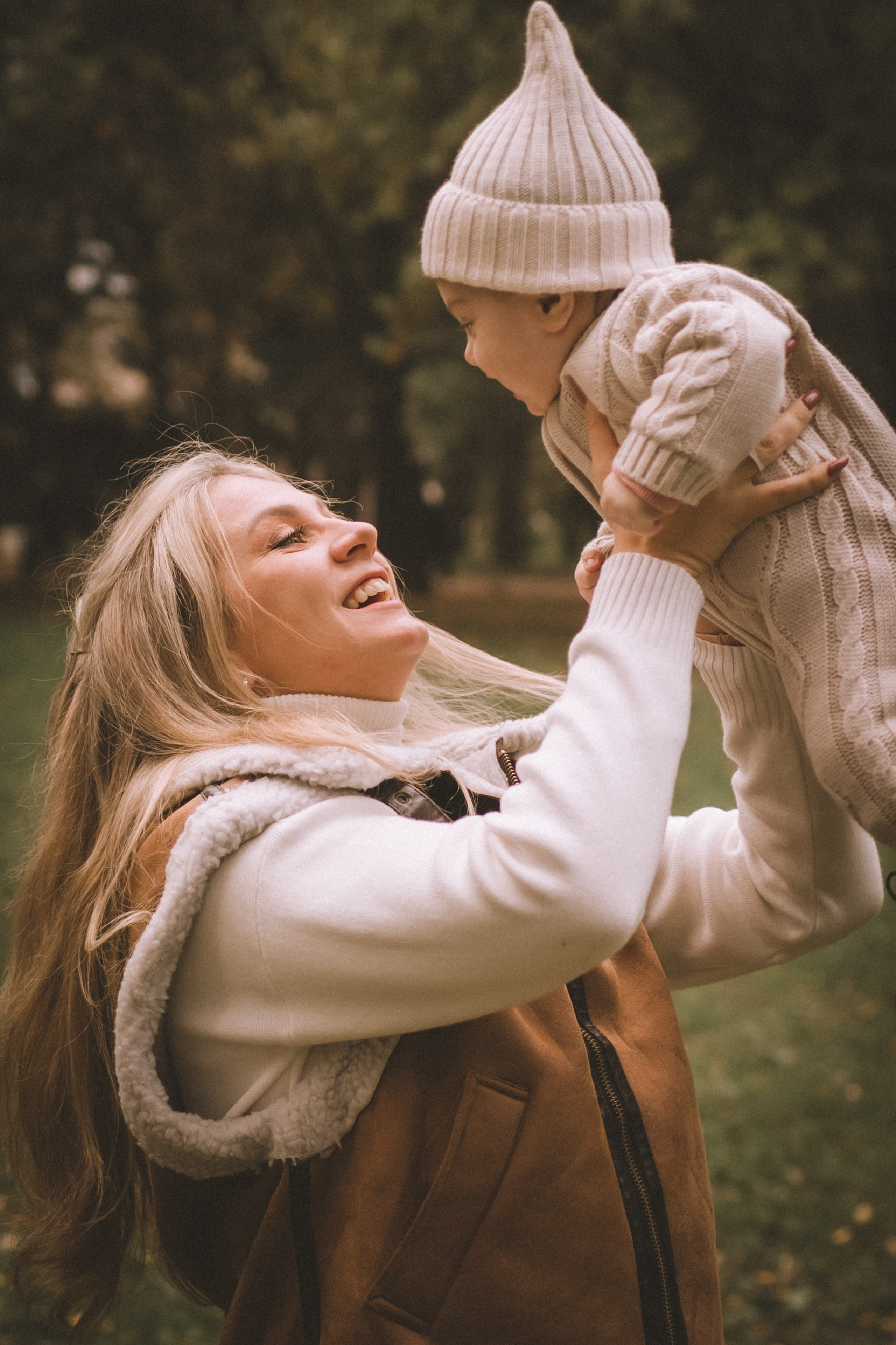 Семейная идиллия: молодая мама с малышкой на руках улыбается в осеннем парке Таврического сада