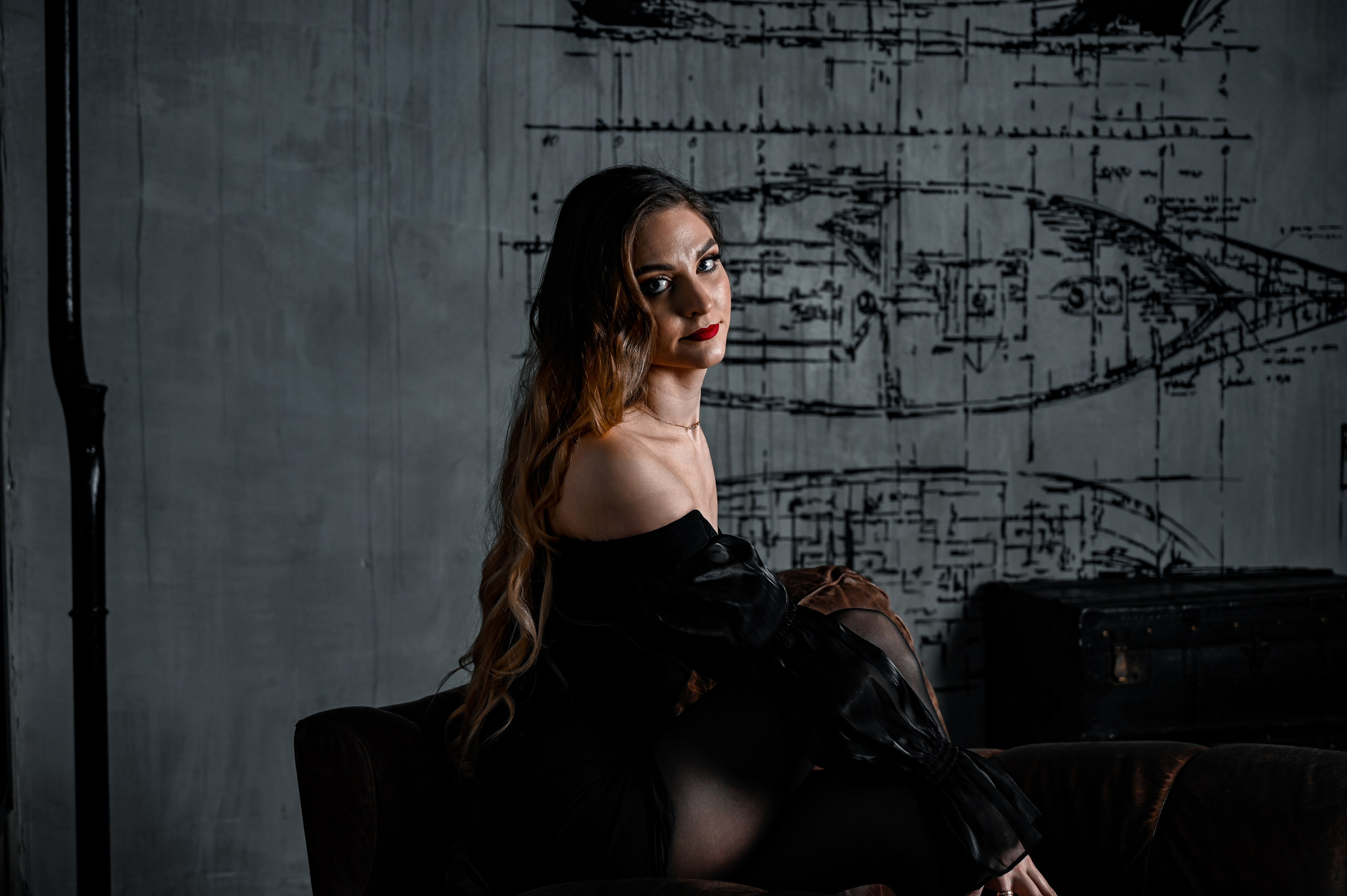 Профессиональный художественный портрет женщины в студии с индустриальным фоном. Эстетичная и атмосферная фотосессия с акцентом на свет, стиль и эмоции — пример студийной работы фотографа для портфолио.