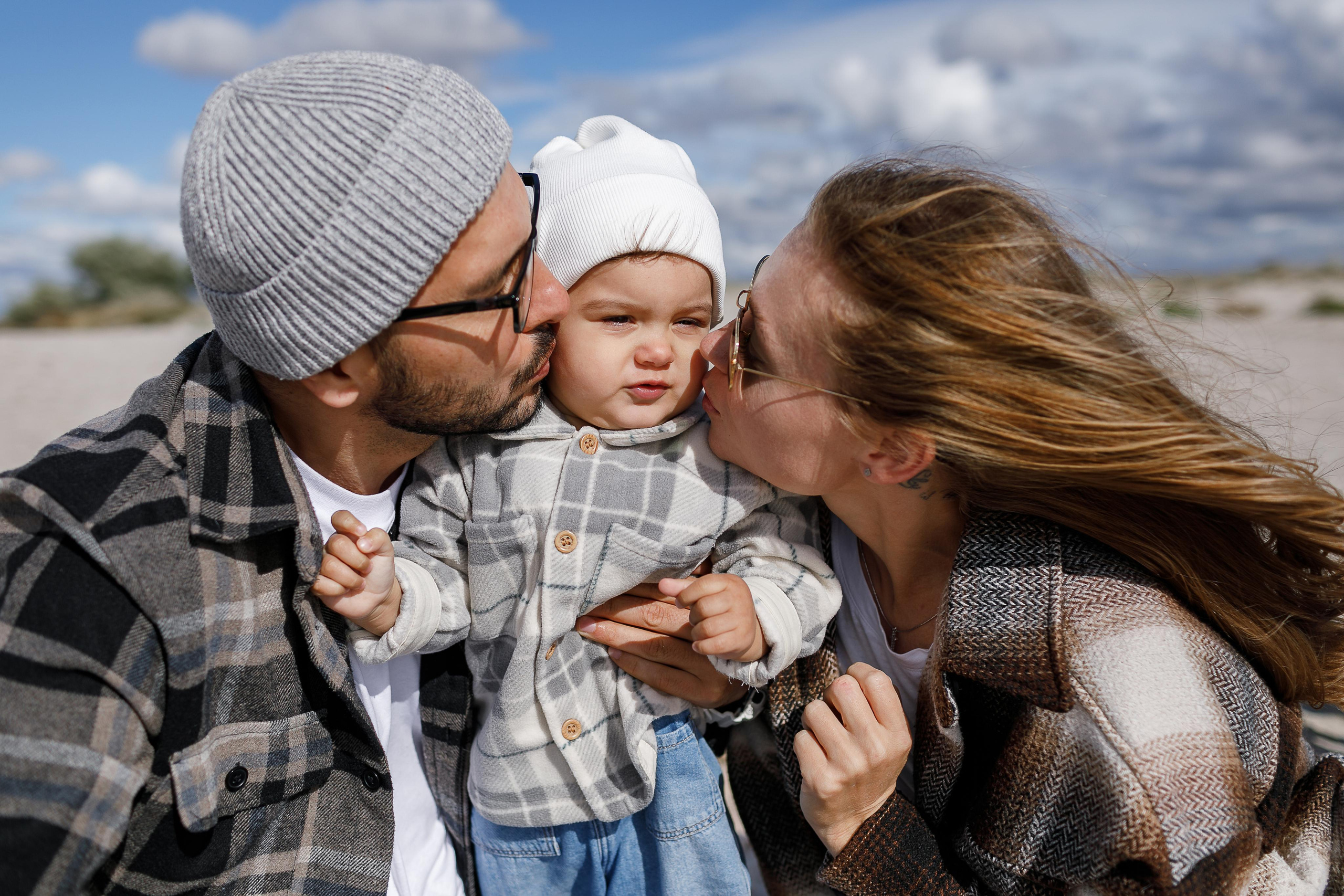 Папа с Мамой целуют в щёчки свою любимую дочку.