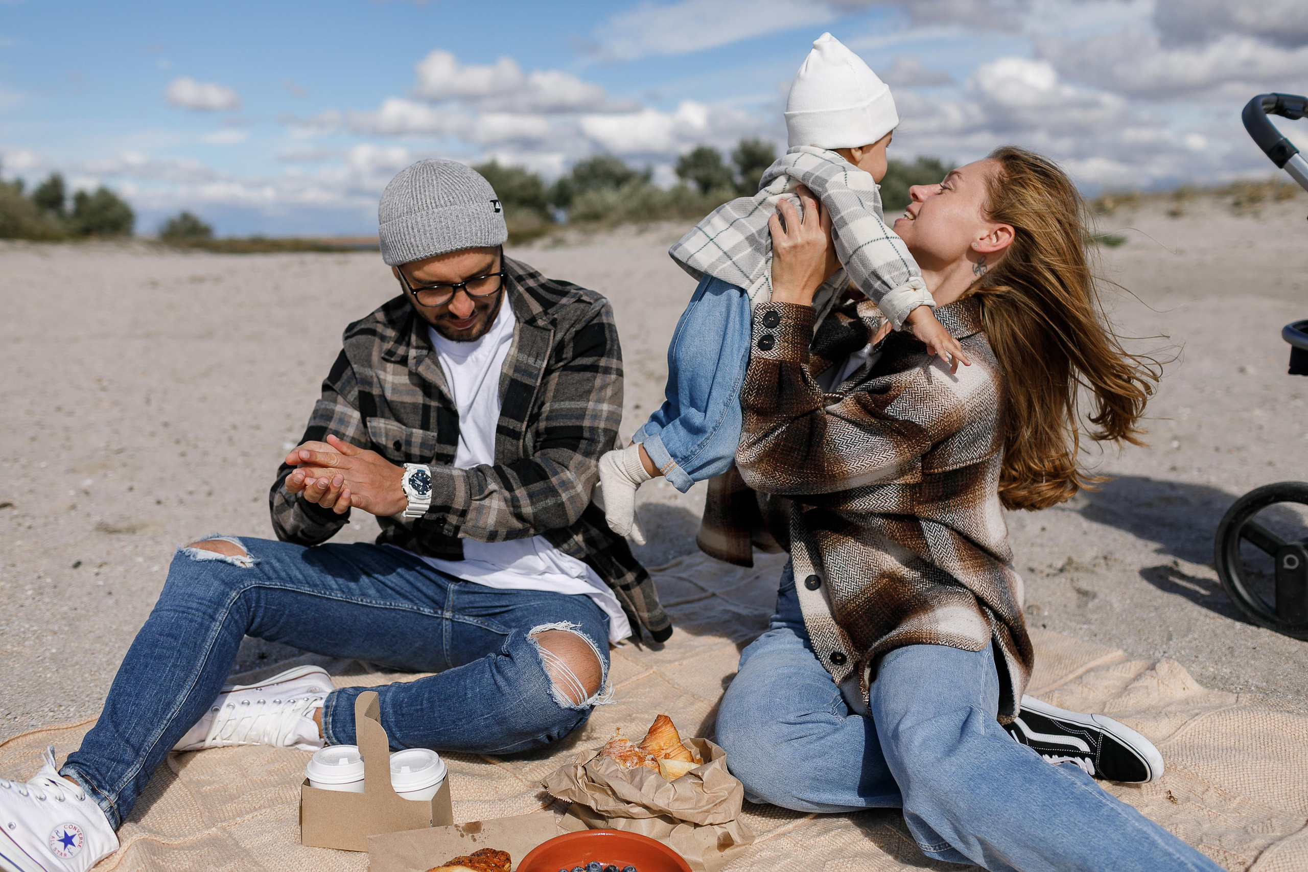 Иры с ребенком на золотом, песочном пляже, солнце слепит в глаза.