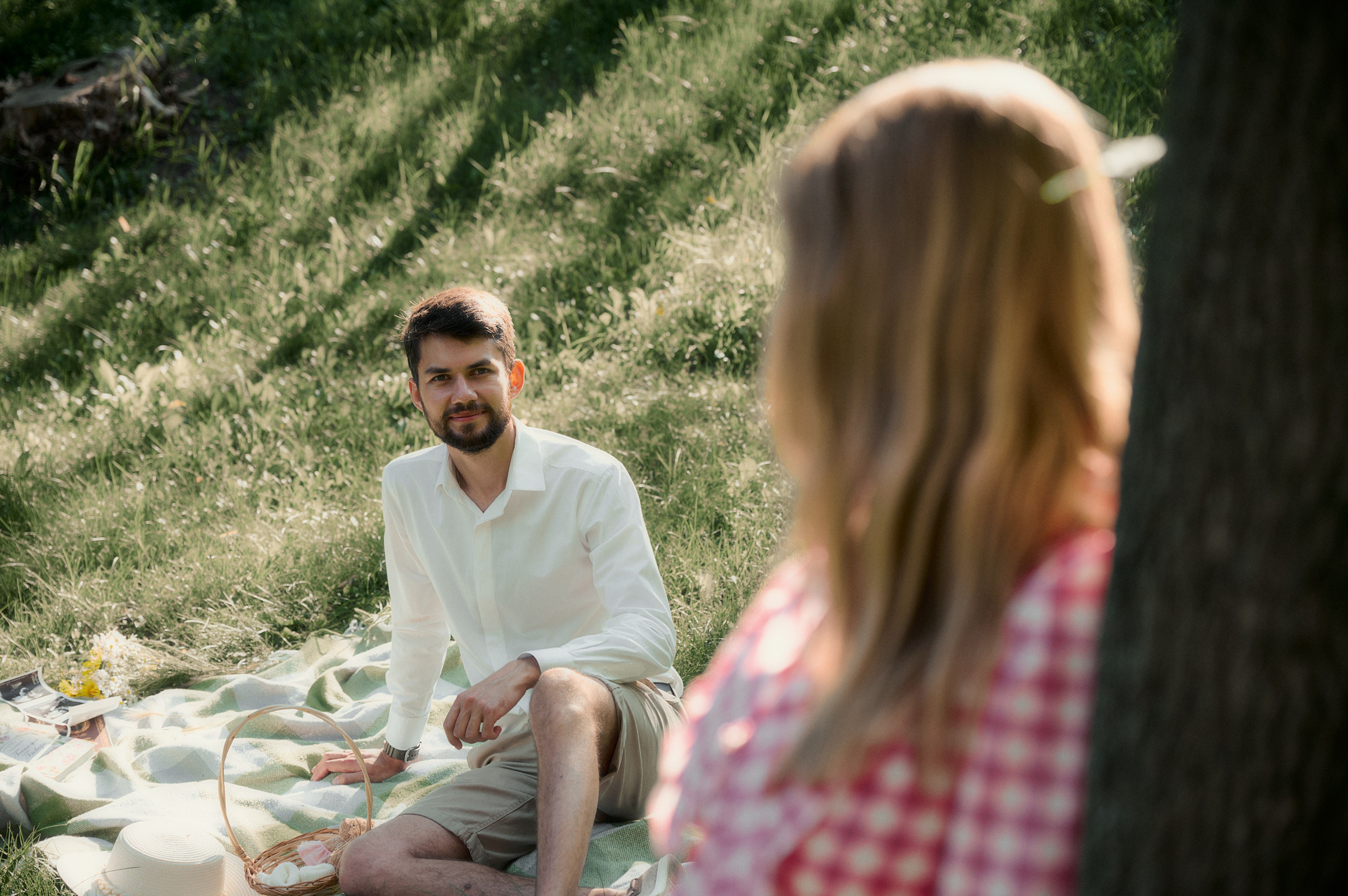 Елизавета стоит у дерева, на заднем плане Юрий улыбается.