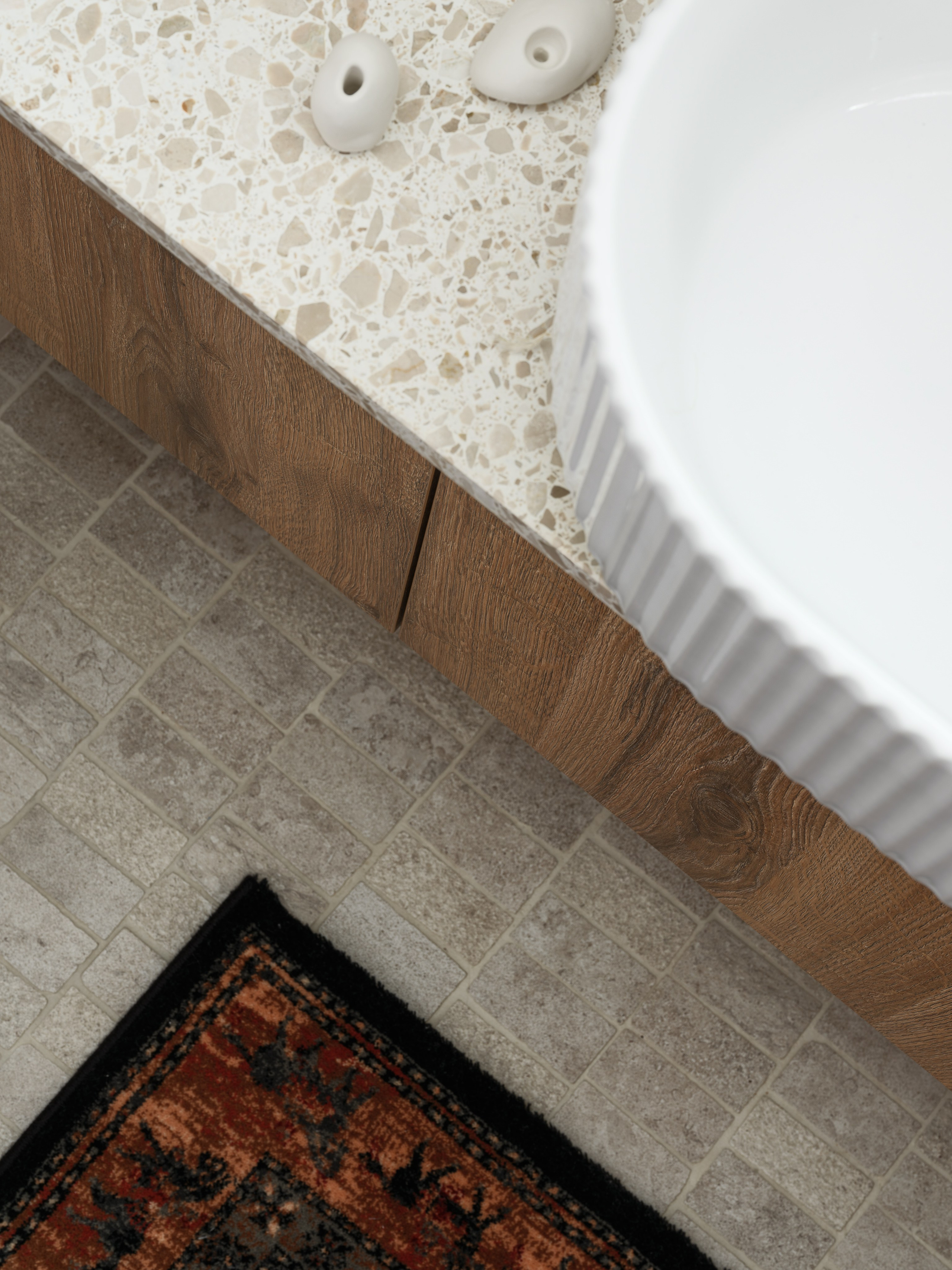 Фрагмент ванной комнаты с каменной столешницей, деревянными фасадами и ковром в восточном стиле, дизайн Наталии Шелепниковой, фото Сергея Денисенко, стиль Алёны Бершацкой.