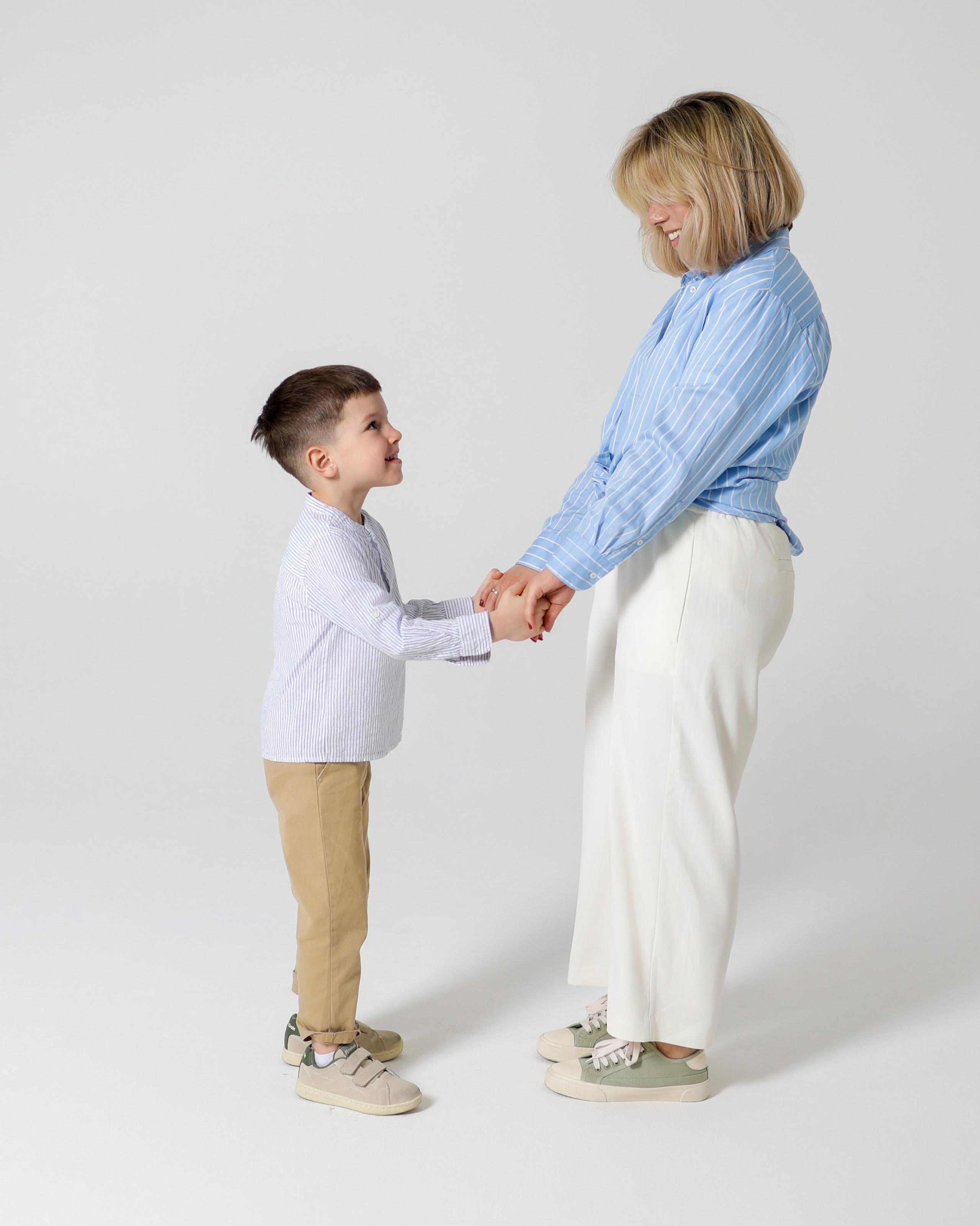 Мама стоит с сыном и держит за руки