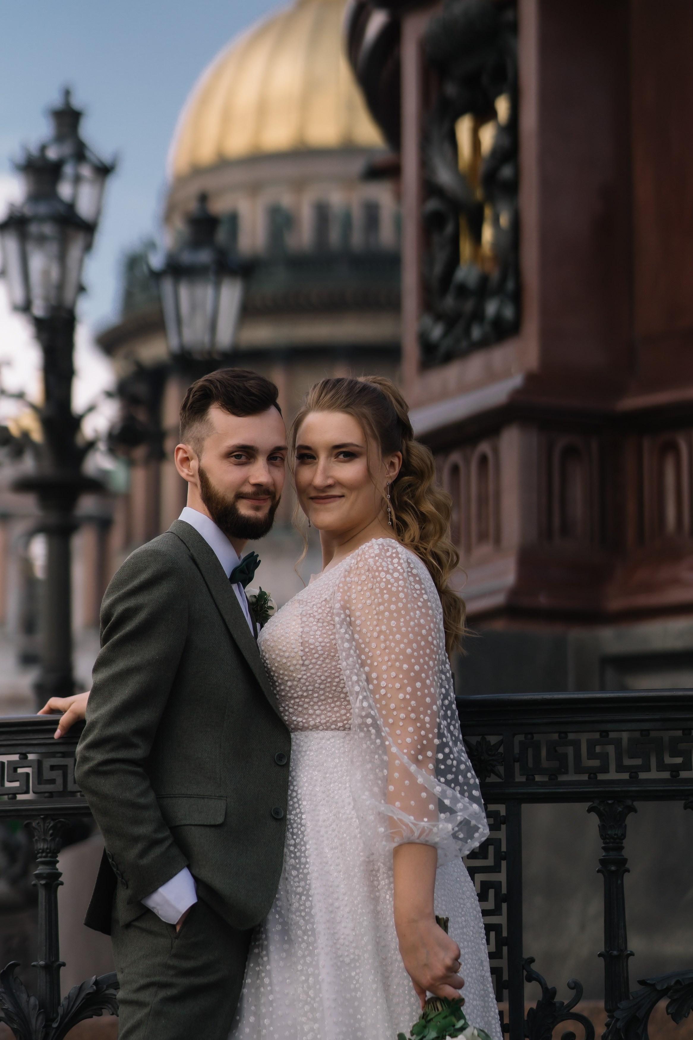 Жених и невеста позируют около фонаря на фоне Исаакиевского собора. Свадебная фотосессия у Исаакиевского собора.