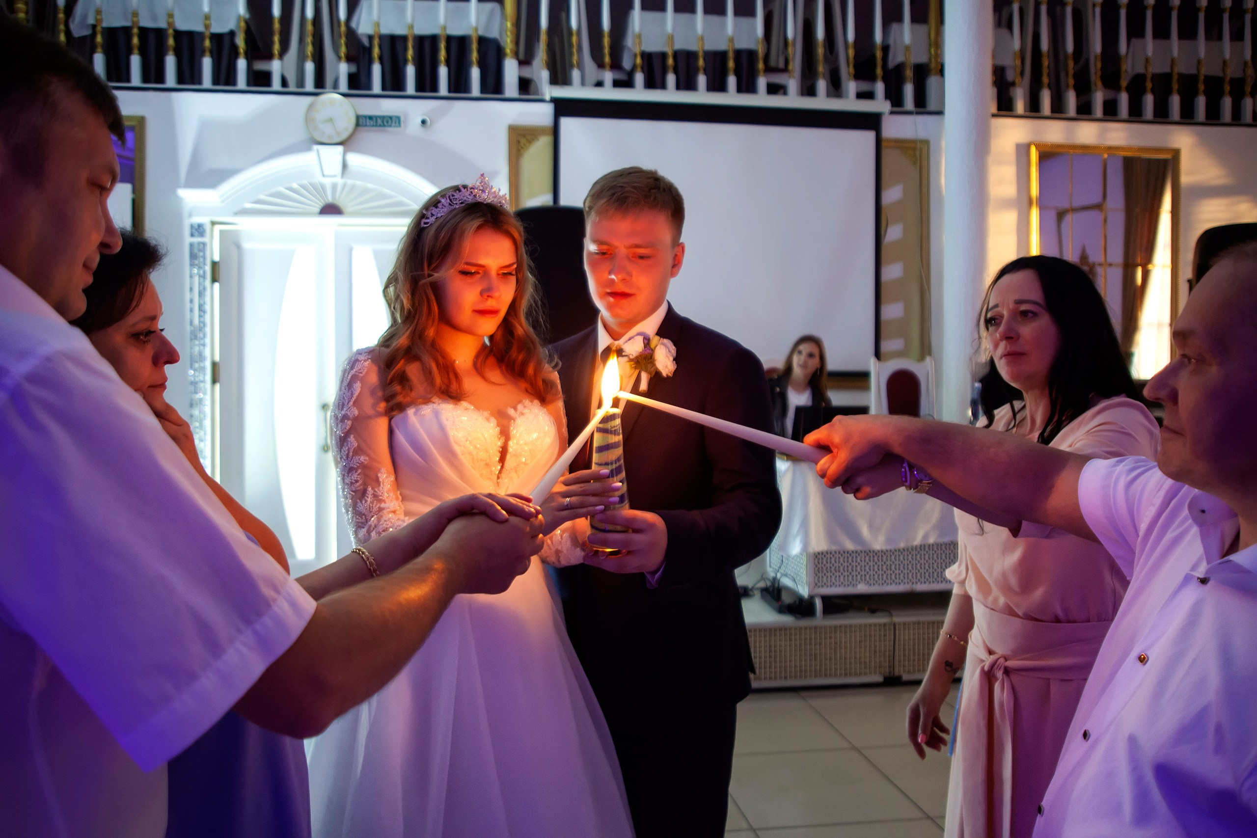 Молодожёны с родителями зажигают свечи 