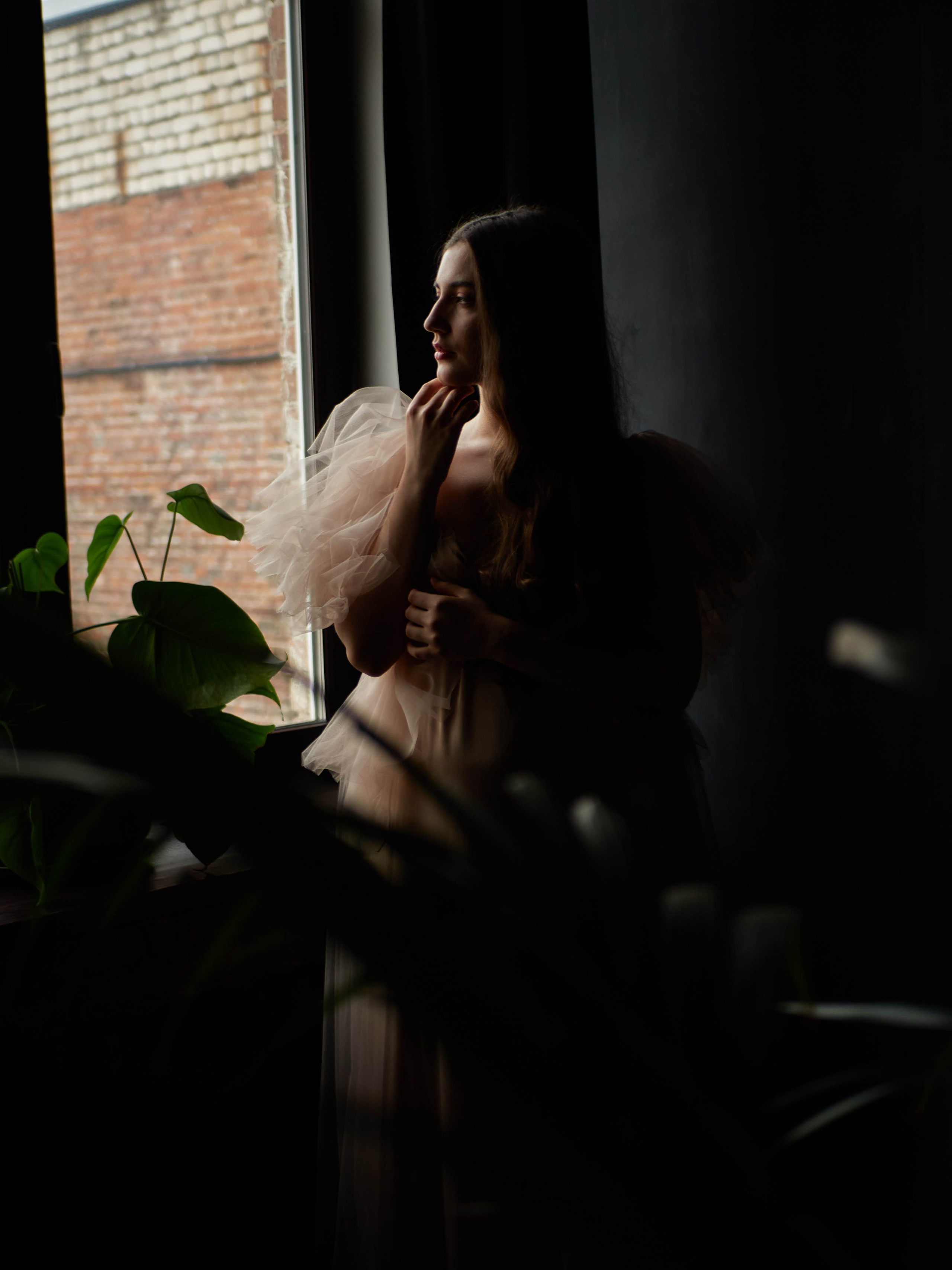 Девушка у окна на тёмном фоне