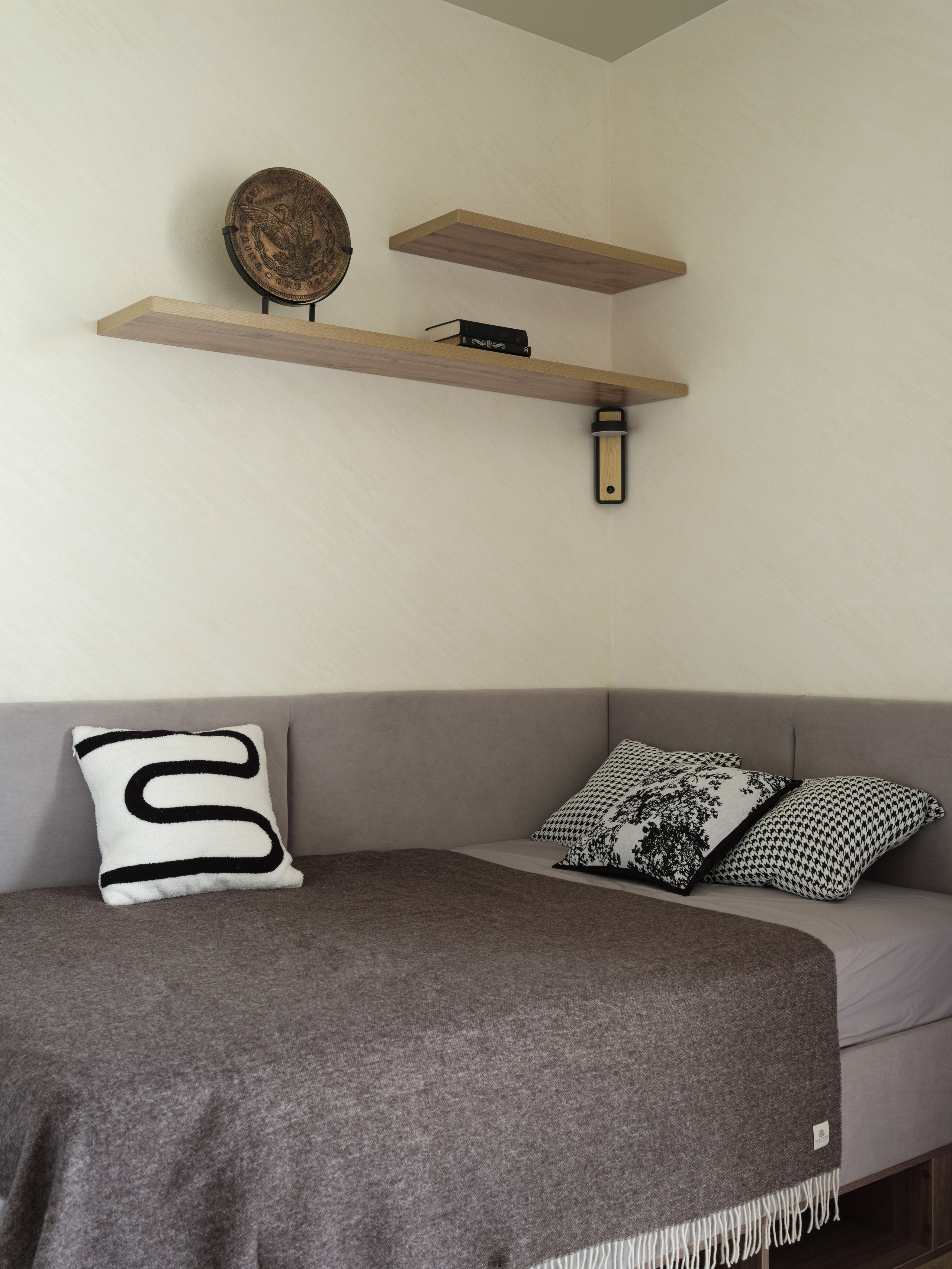 Минималистичная спальня в нейтральных тонах с мягкой кроватью и декоративными подушками, оформленная дизайнером Алиной Дёровой. Стильный текстиль, деревянные полки и акценты подобраны Натальей Якушевой, фото Сергея Денисенко.