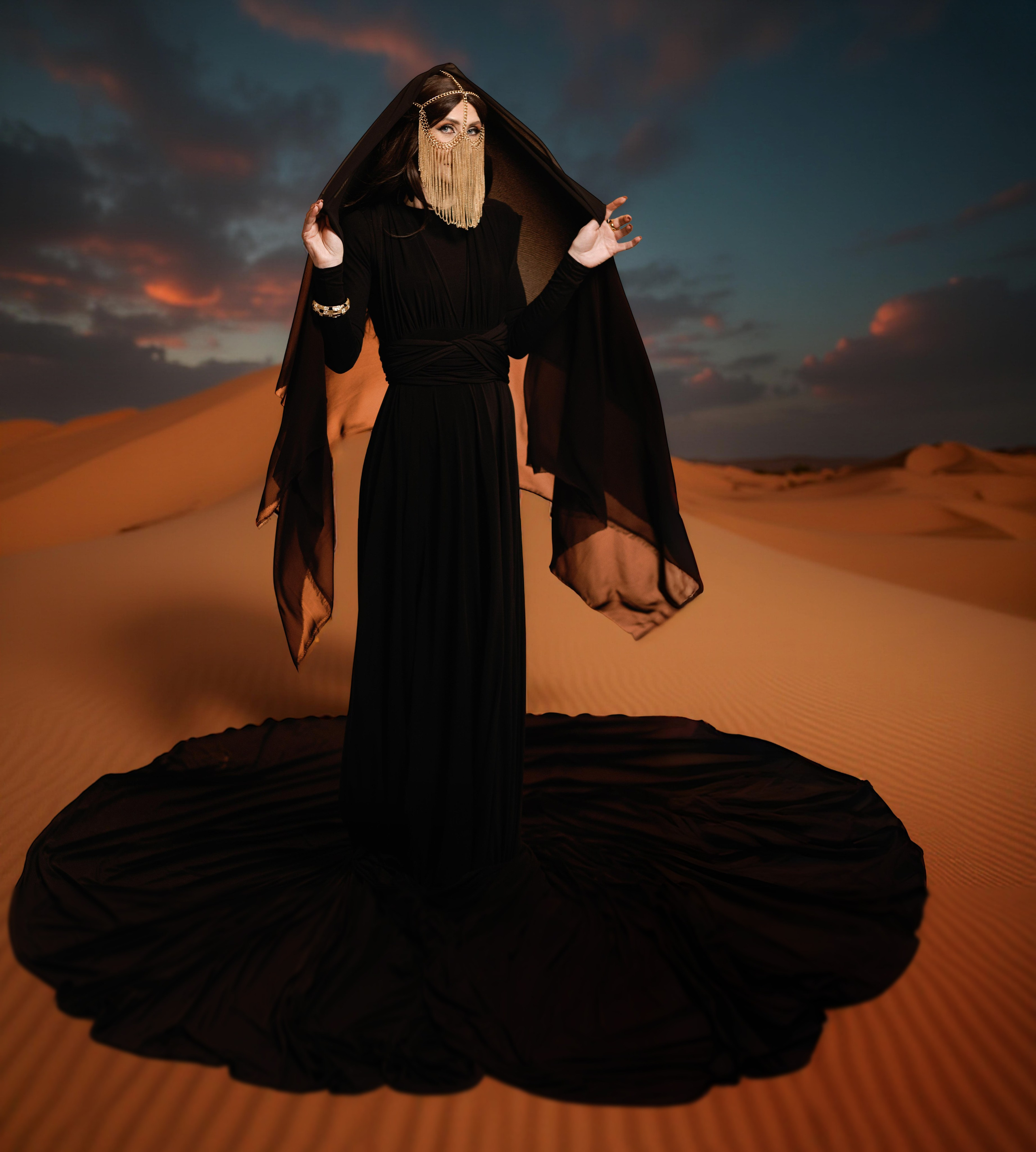 Фотосессия восточная женщина - портрет в рост в черном хиджабе с украшениями на лице.