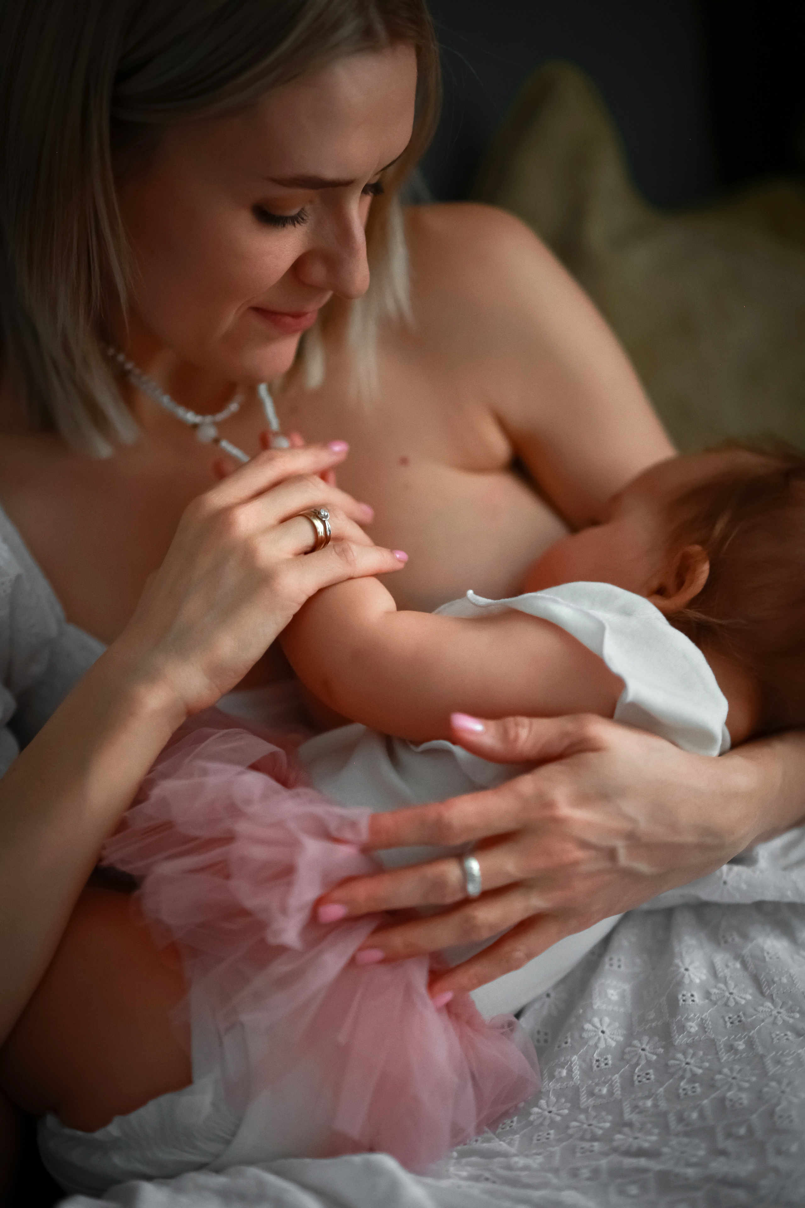 Нежный фото портрет кормащей мамы, которая ласково смотрит на свою дочь.