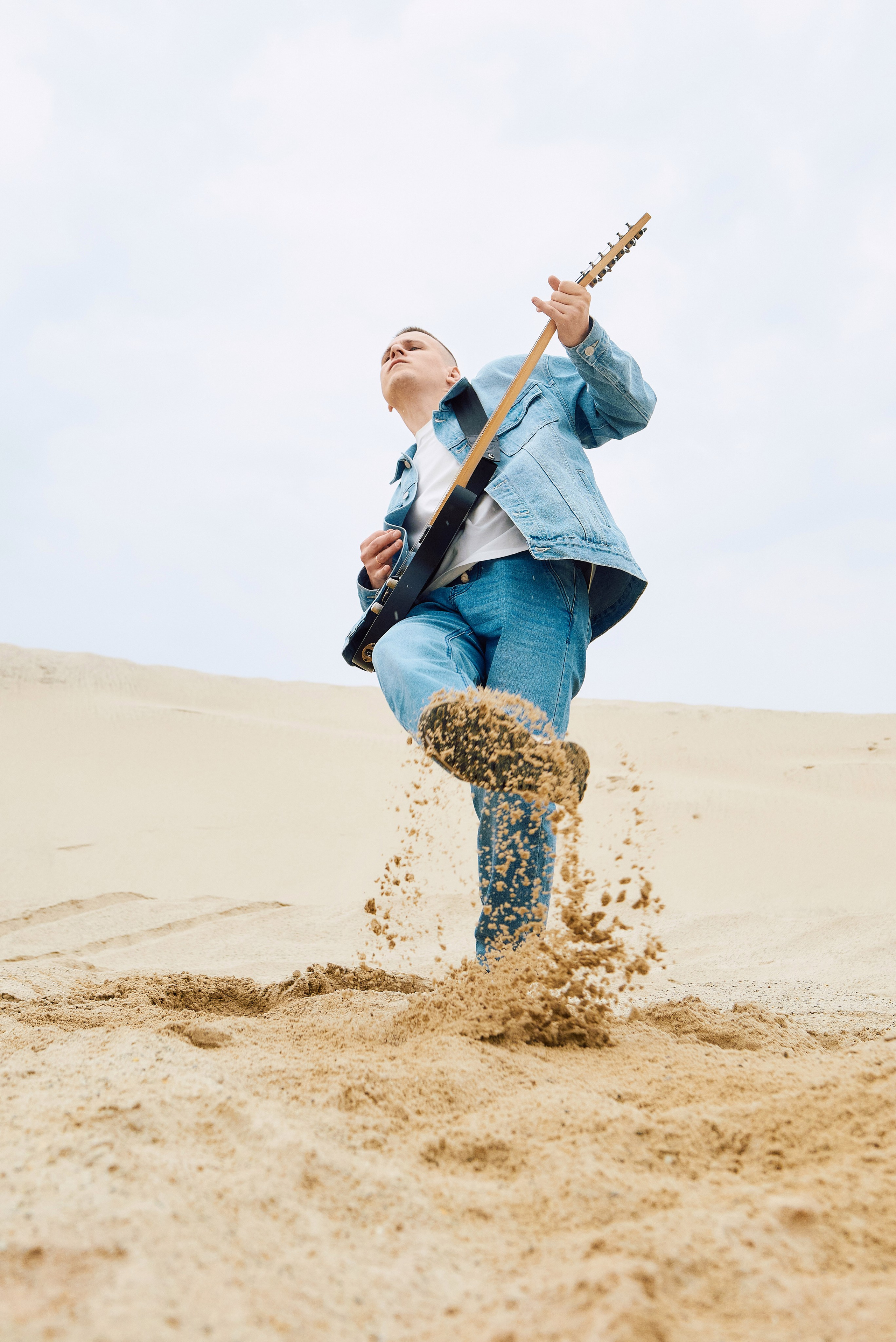 Парень играет на гитаре в пустыне