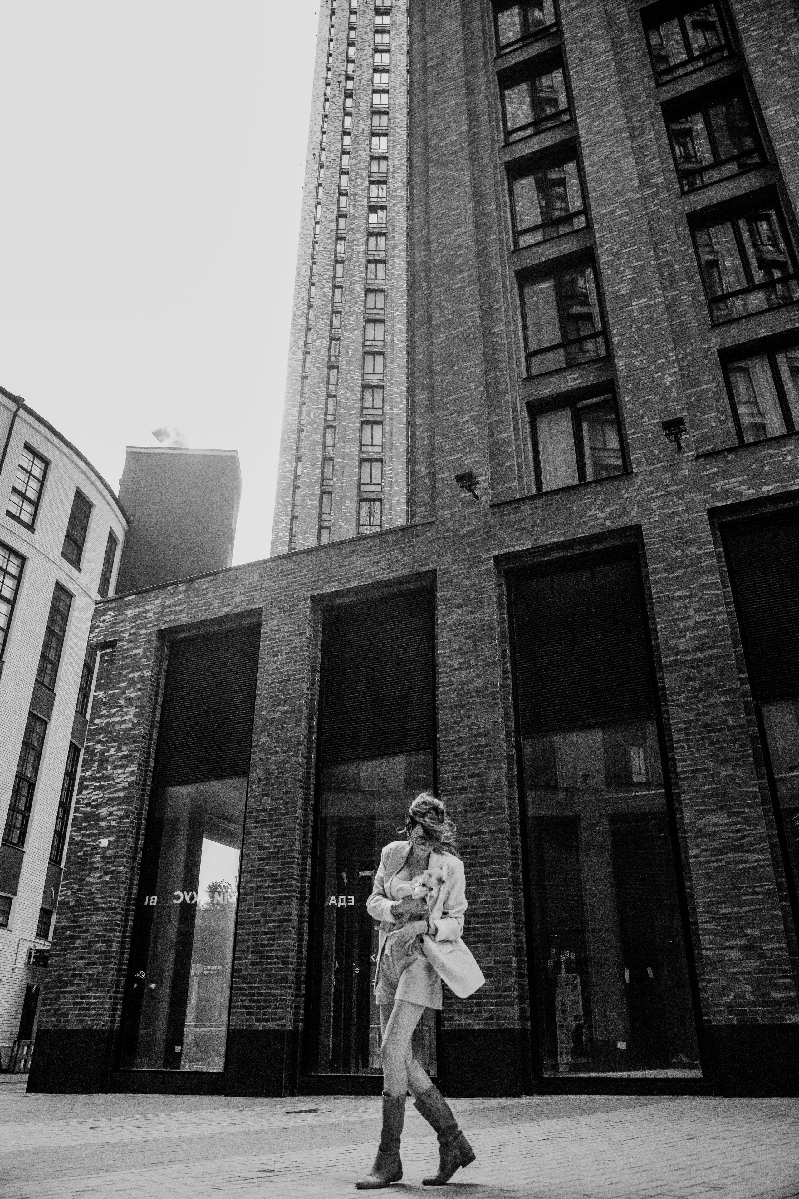 привлекательная молодая девушка гуляет со своей собачкой   по Москве весной в ясный теплый день