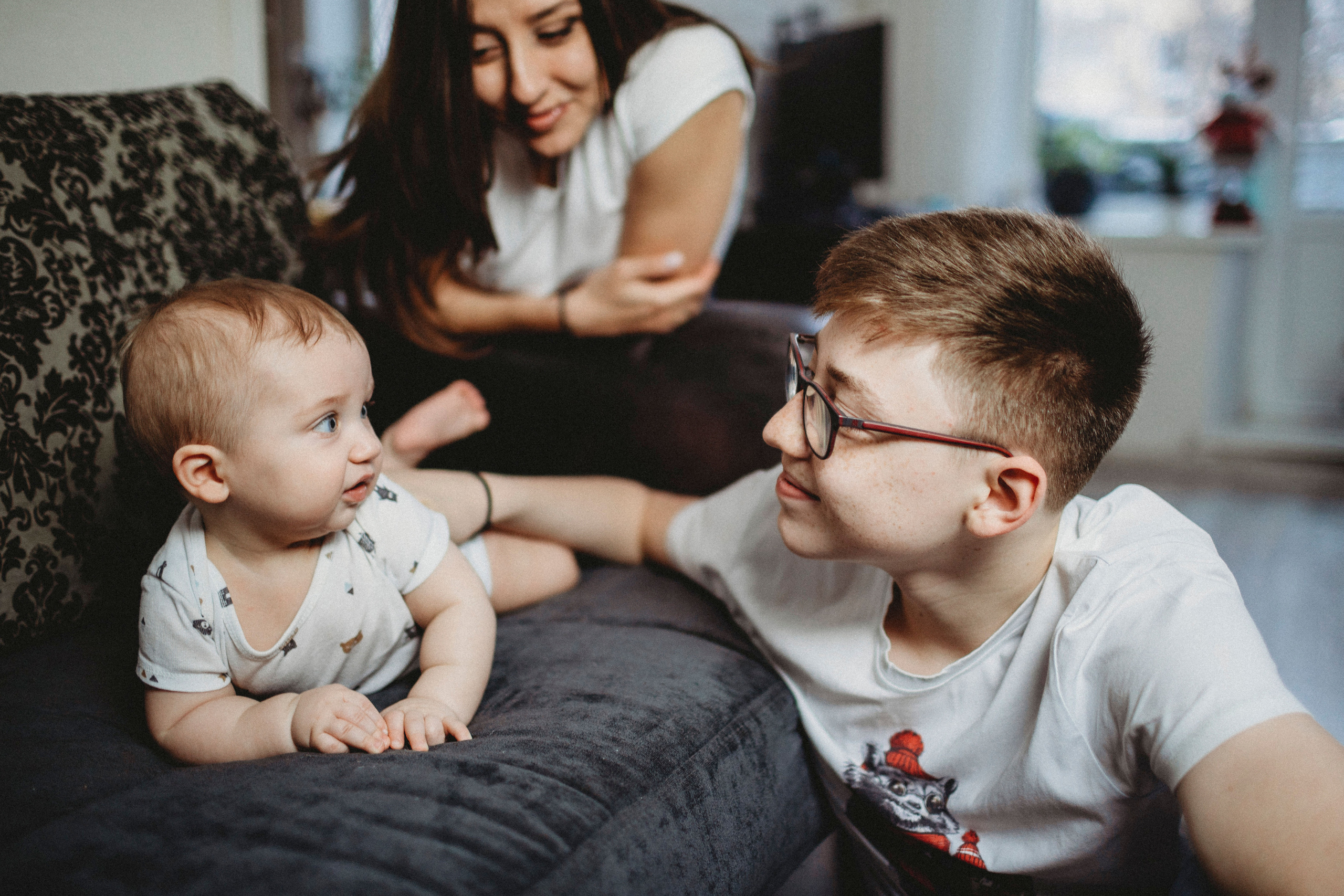 маленький братик играет со своим старшим братьм дома