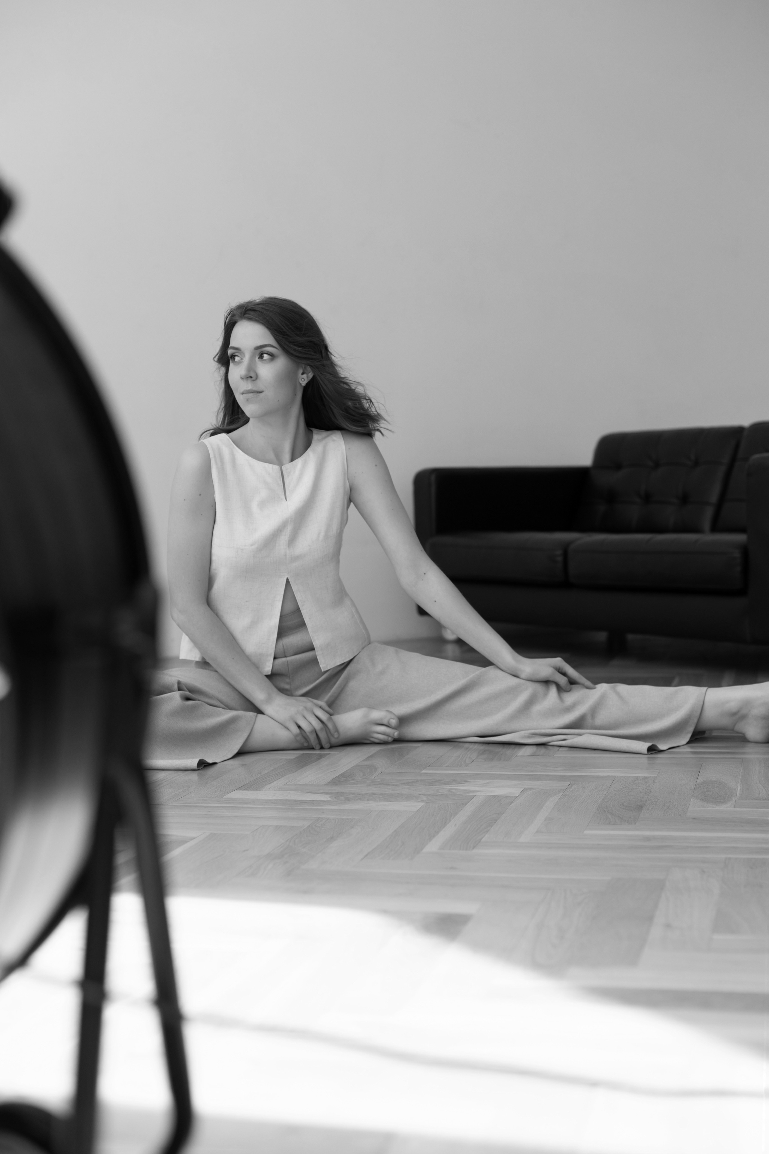 фото девушки, которая сидит на полу перед диваном с вытянутой ногой