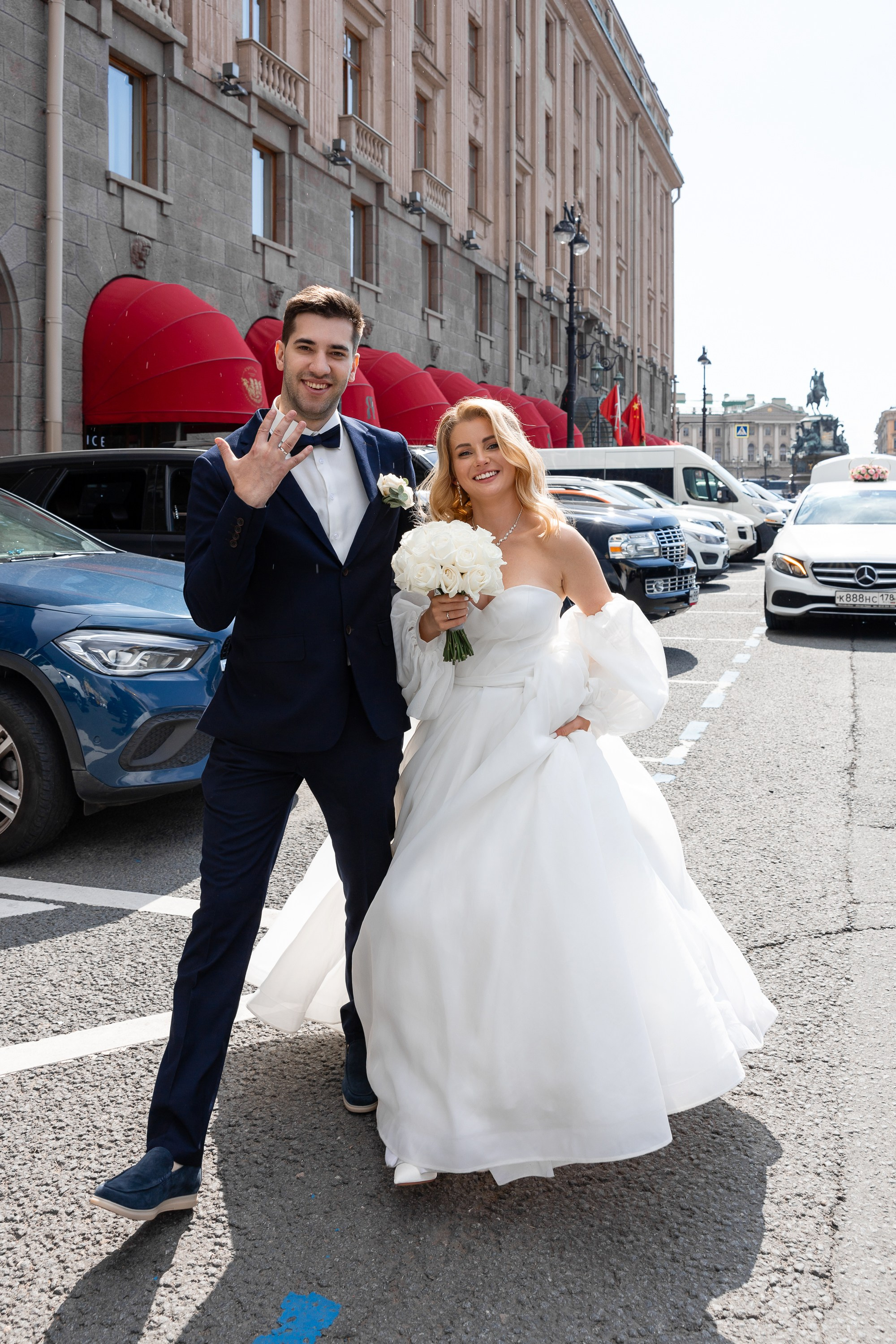 Жених хвастается кольцом на пальце у гостиницы Астория