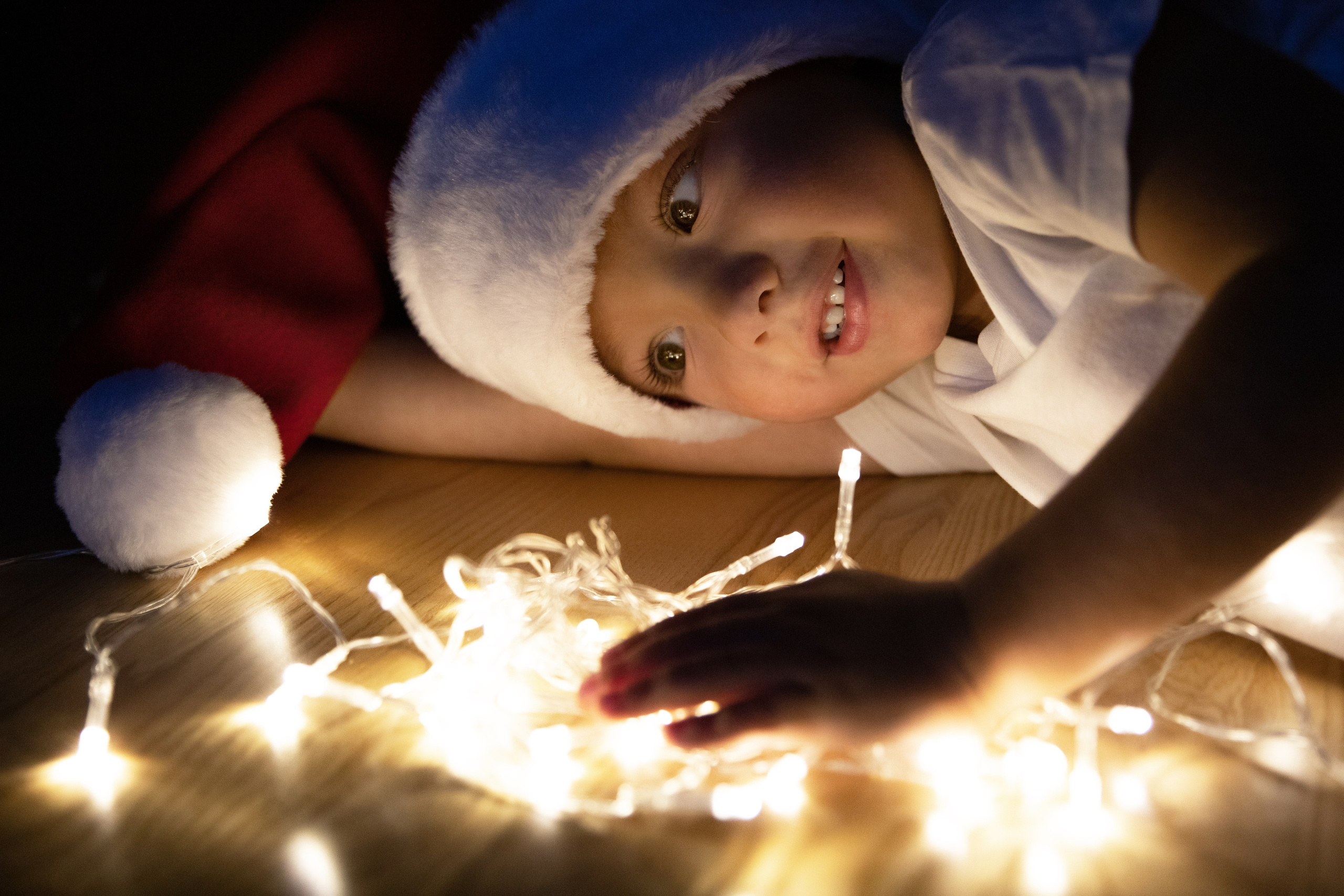 A brother and sister with lights and candles play on Christmas night and celebrate New Year's Eve. Photographer in Algarve, Portugal