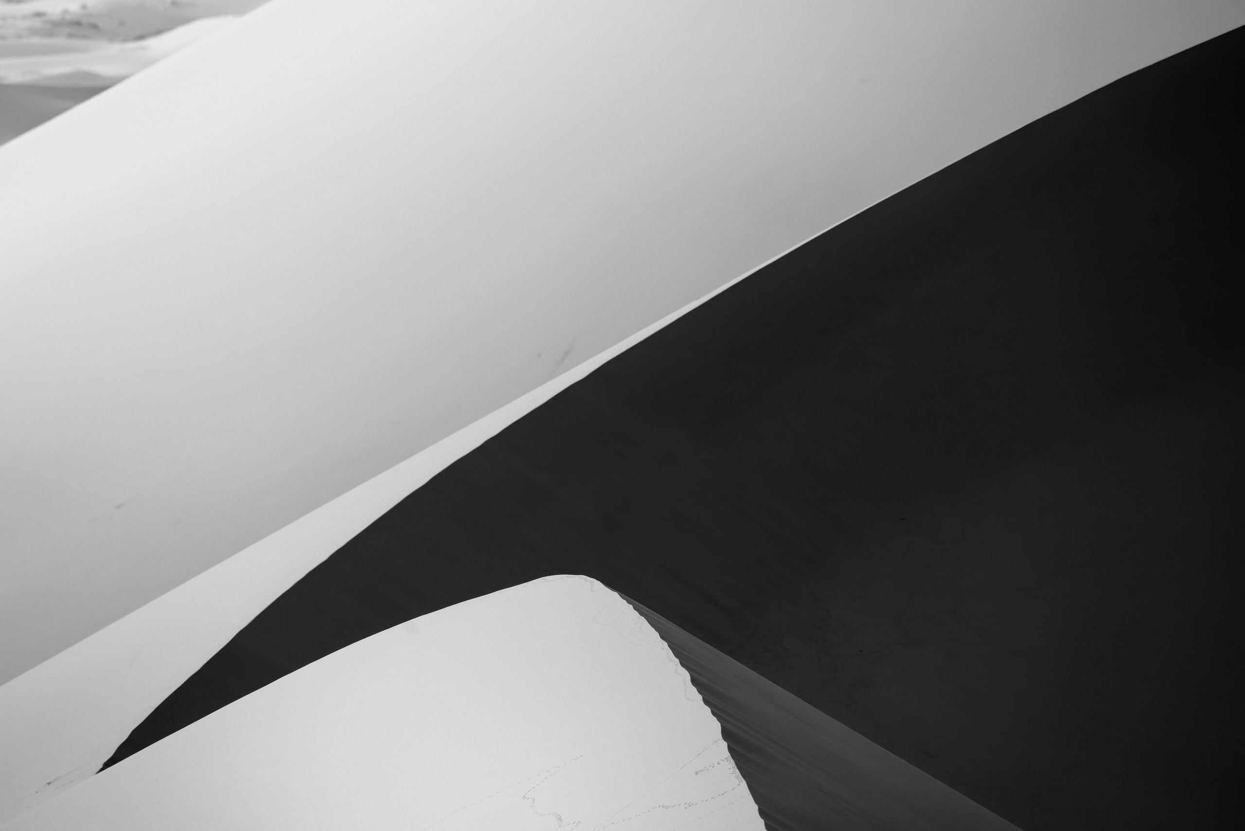 Контрастные изгибы дюн на рассвете в ЧБ