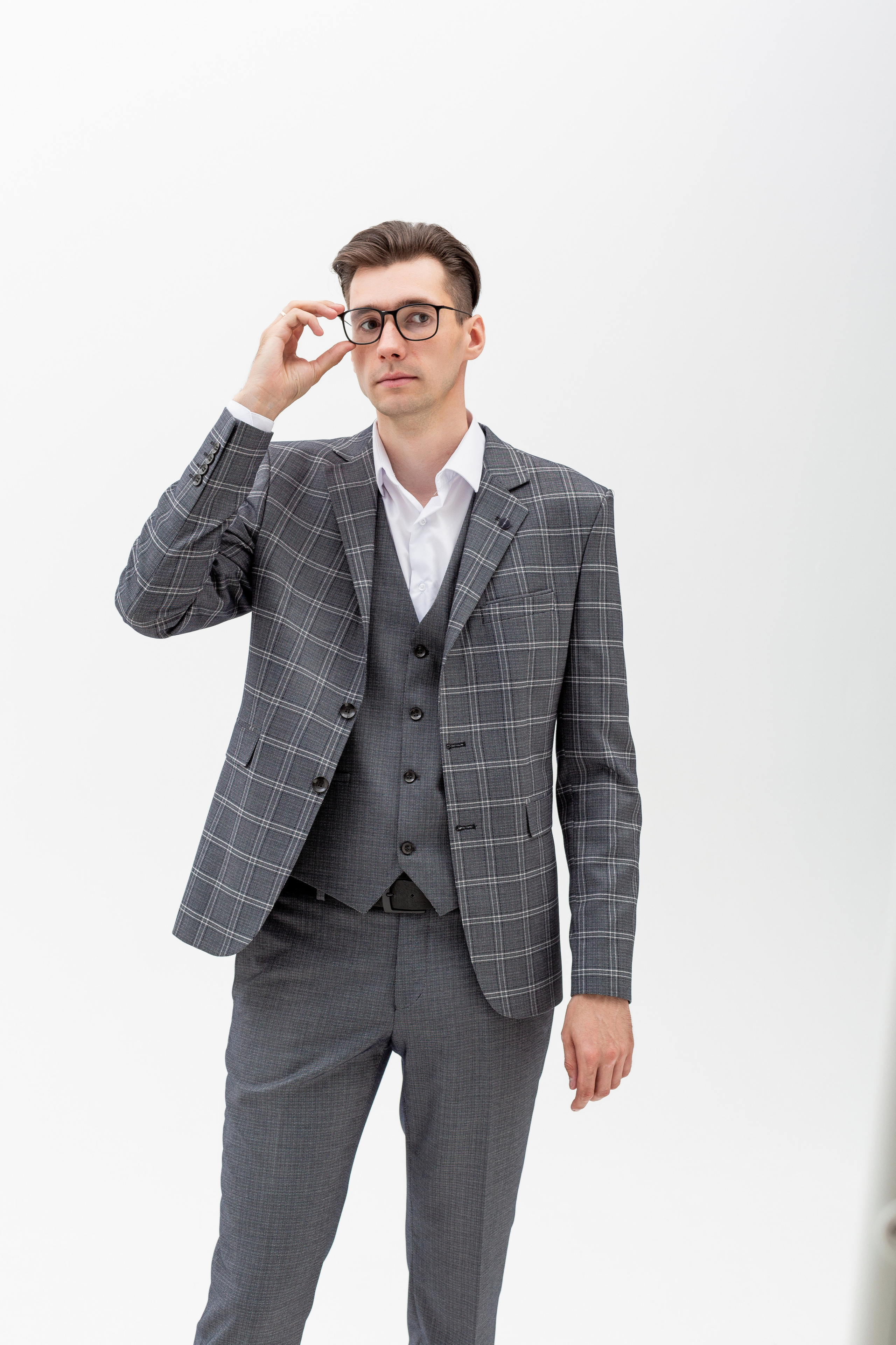 Студийный портрет мужчины в очках, портрет 2/3, в костюме тройка на белом фоне