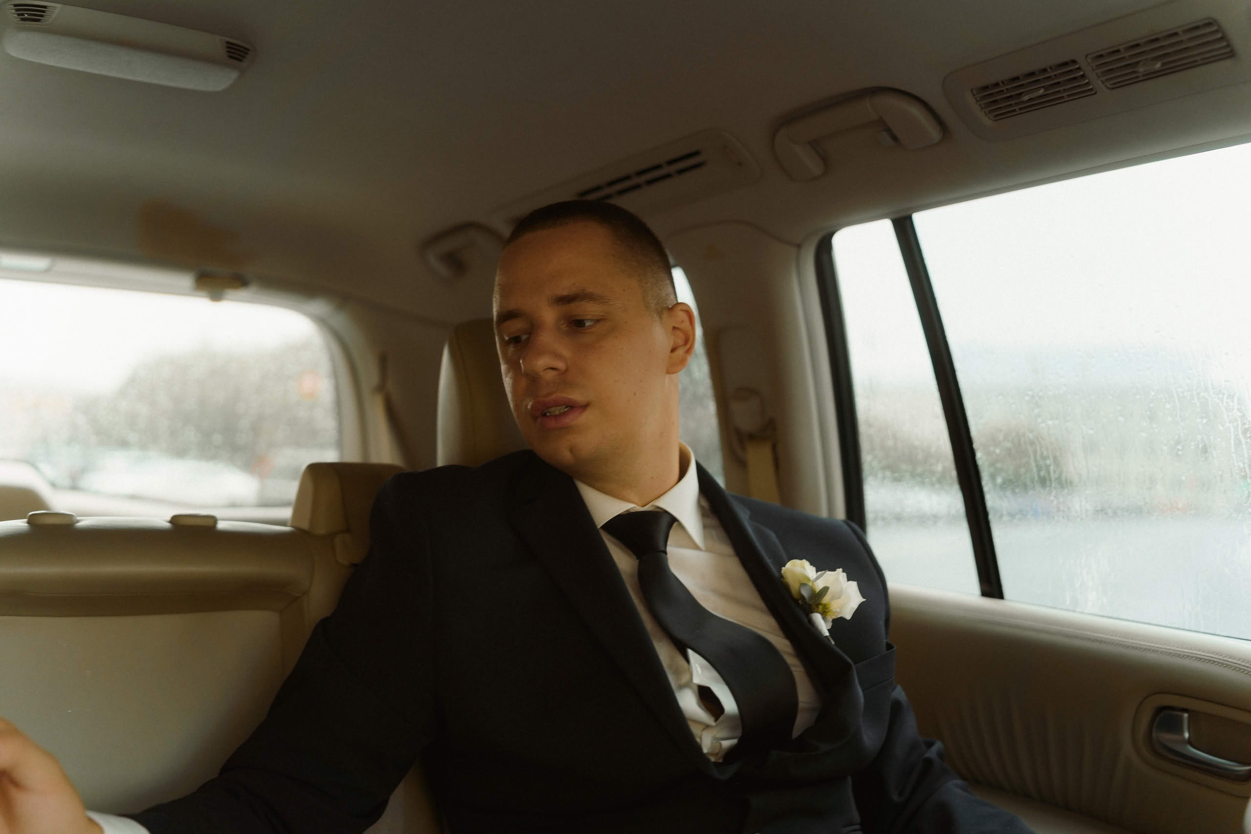 Жених Илья в костюме в свадебном автомобиле