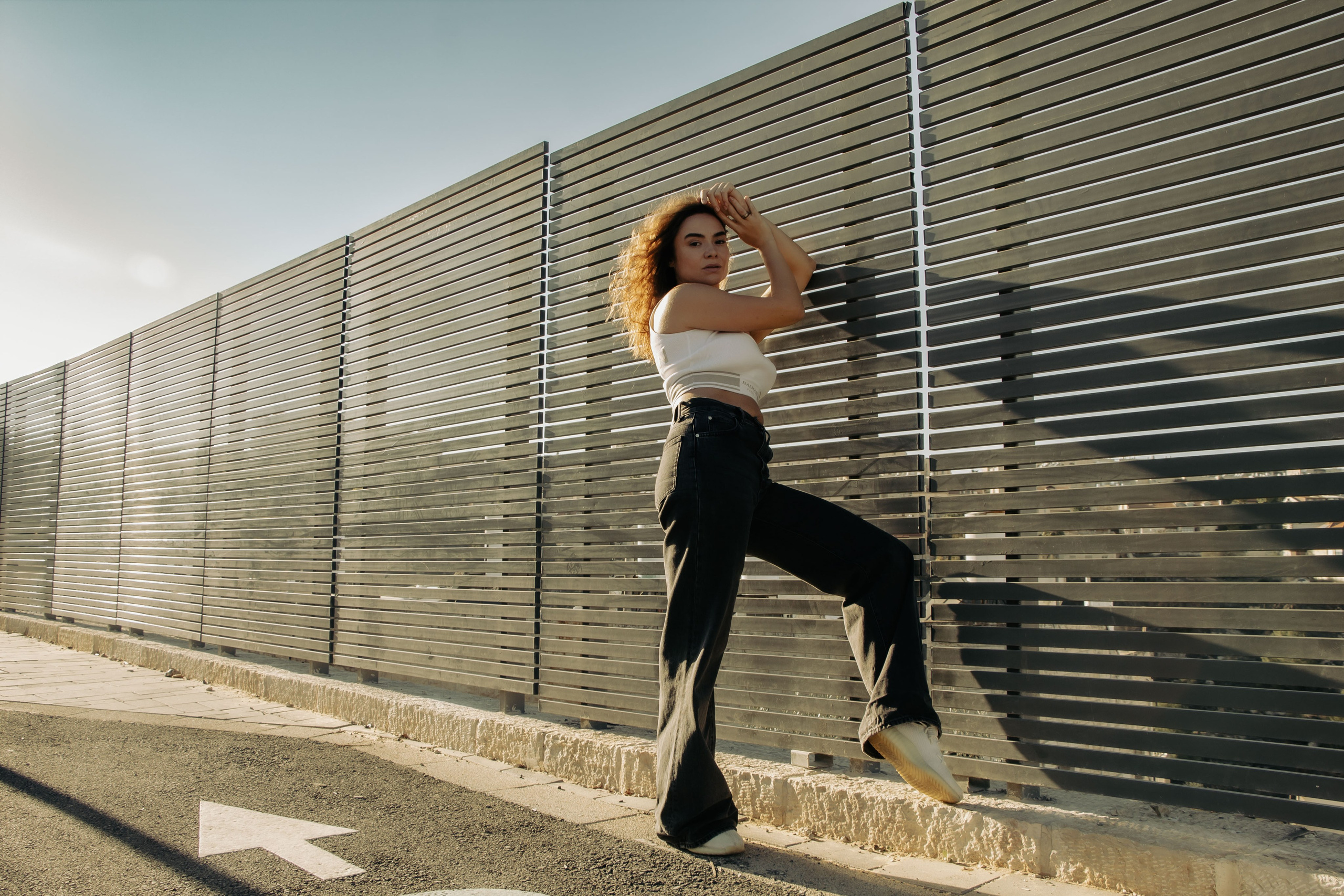 девушка стоит возле забора 