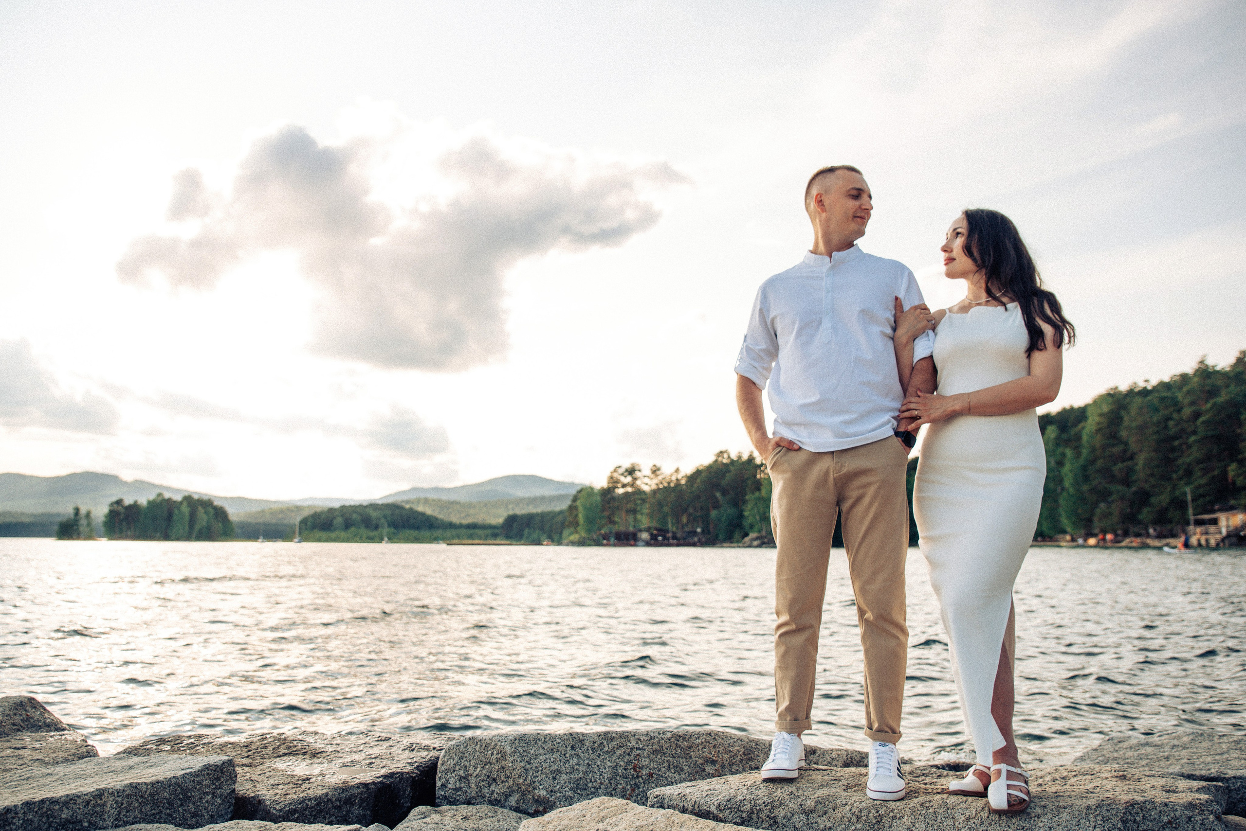 Семейная прогулка летом на берегу озера по пляжу