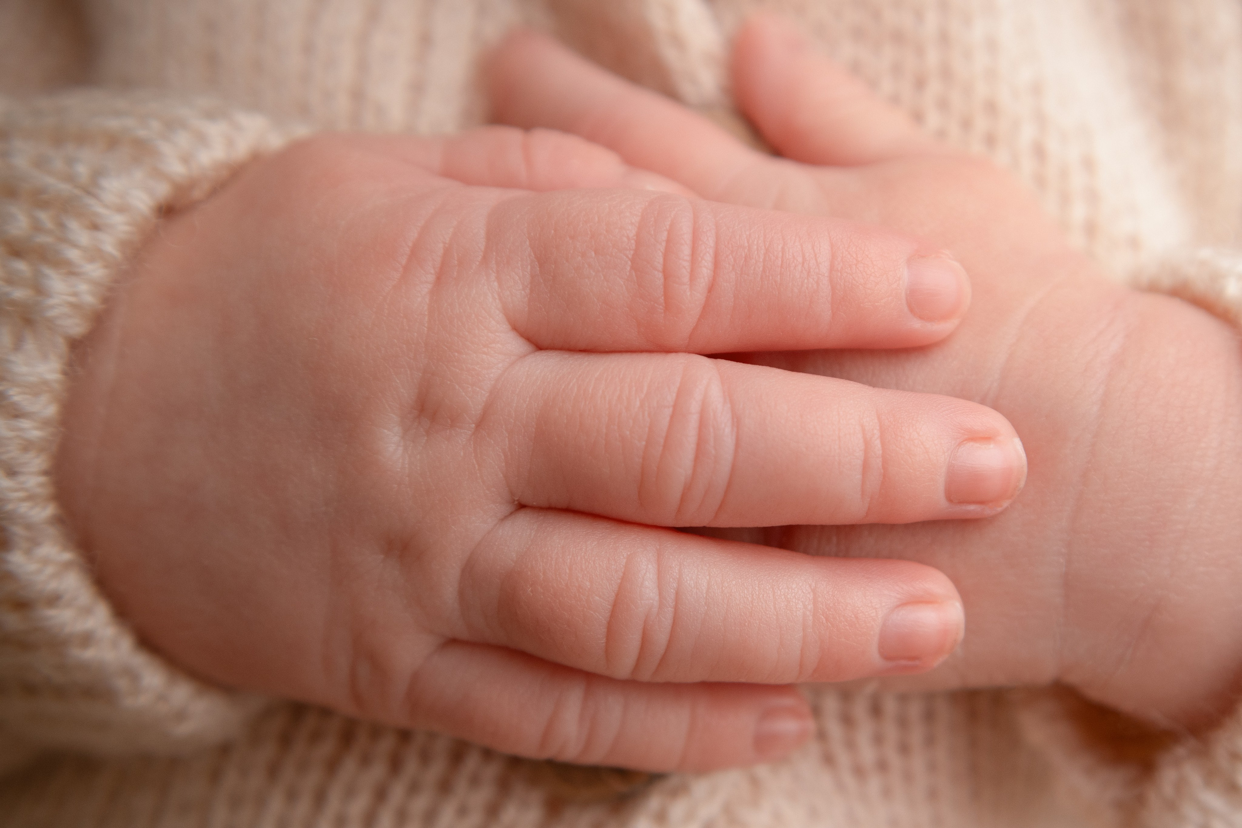 Ручки новорожденного ребёнка в костюмчике