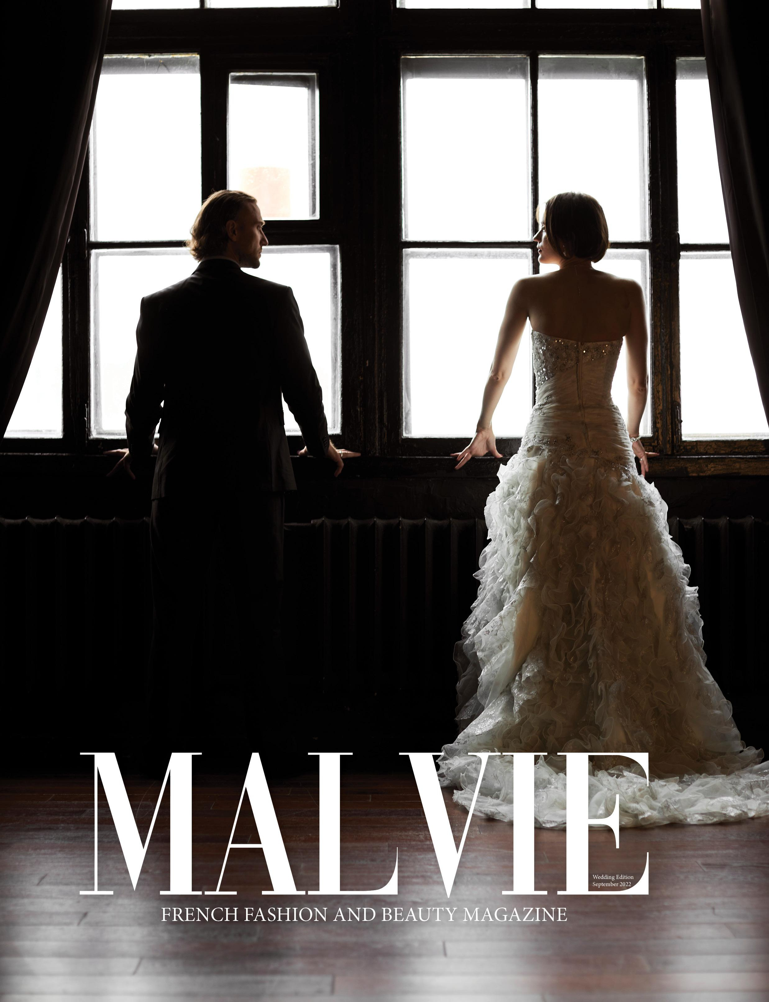 Пара влюблённых стоят и смотрят в окно, вид со спины