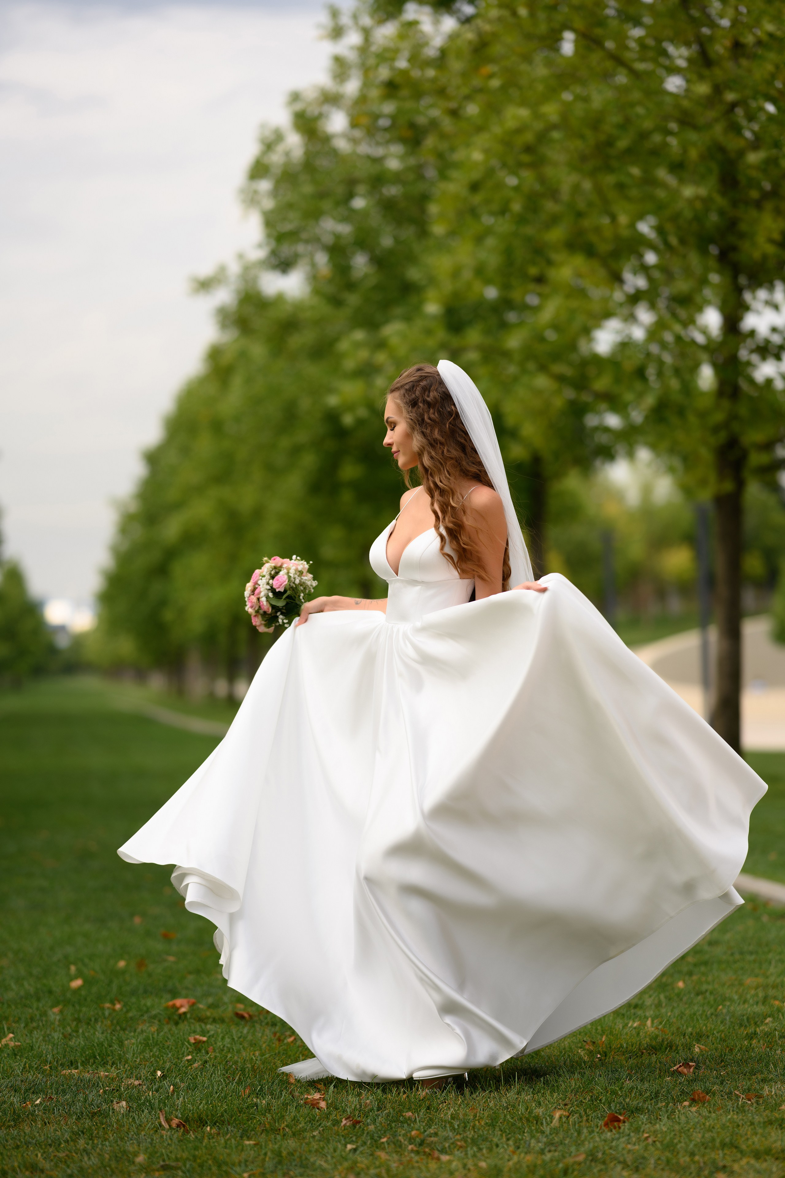 Красивое фото как невеста кружится на траве.