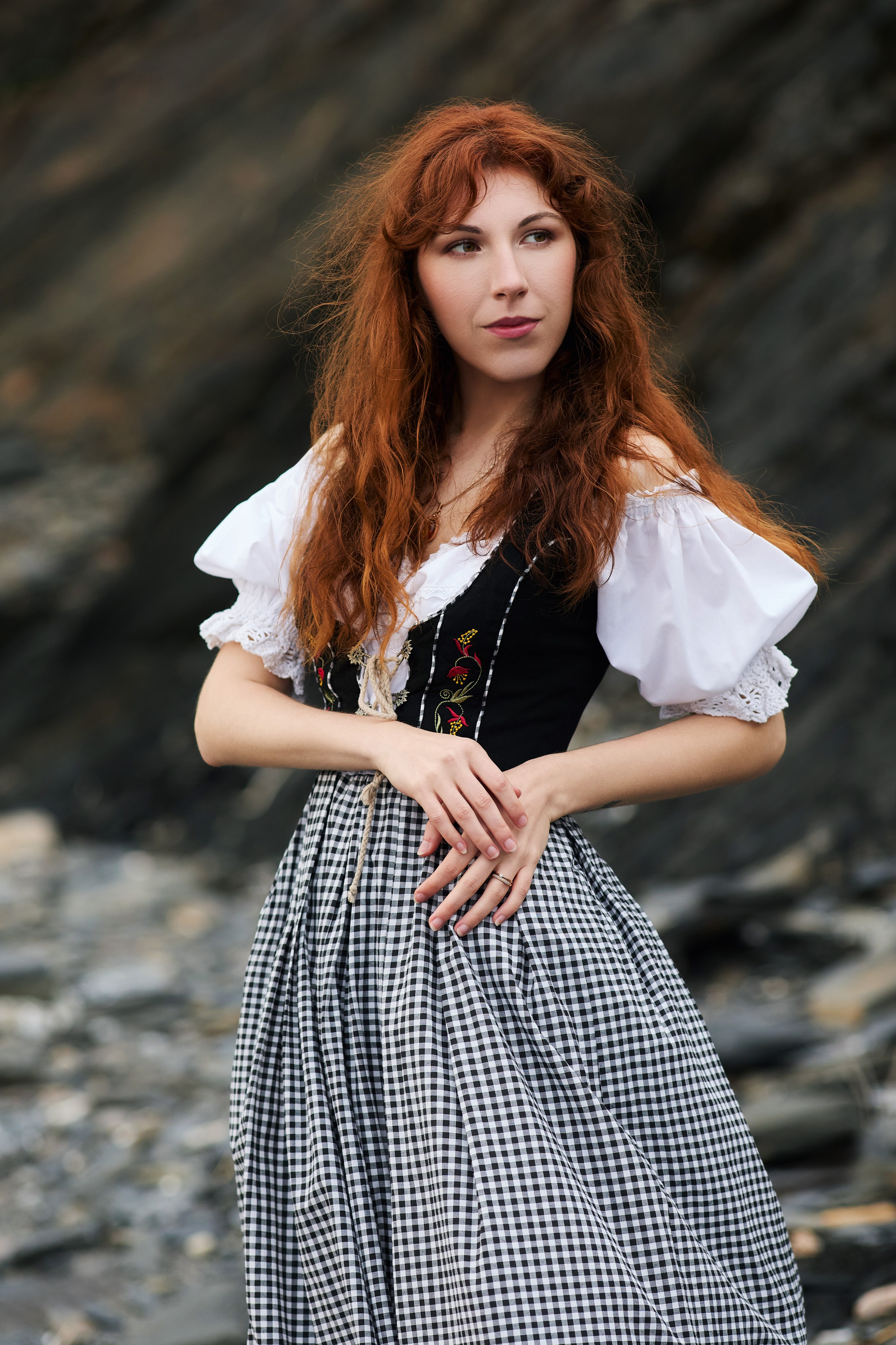 Фэнтези фотосессия с очаровательной рыжеволосой женщиной, позирующей на фоне чёрных морских скал на пляже Тунгус в Находке