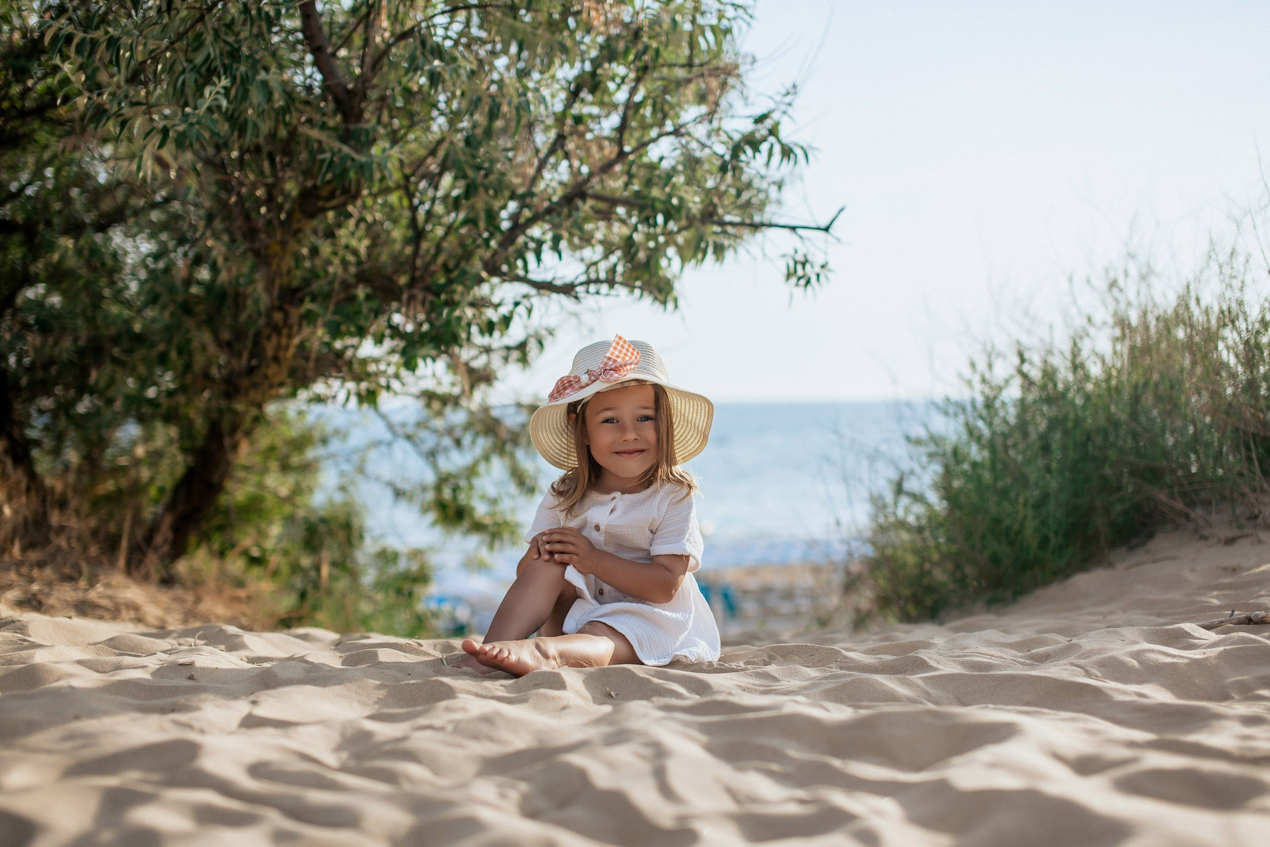 Маленькая девочка позирует на фоне моря в дюнах Джемете.