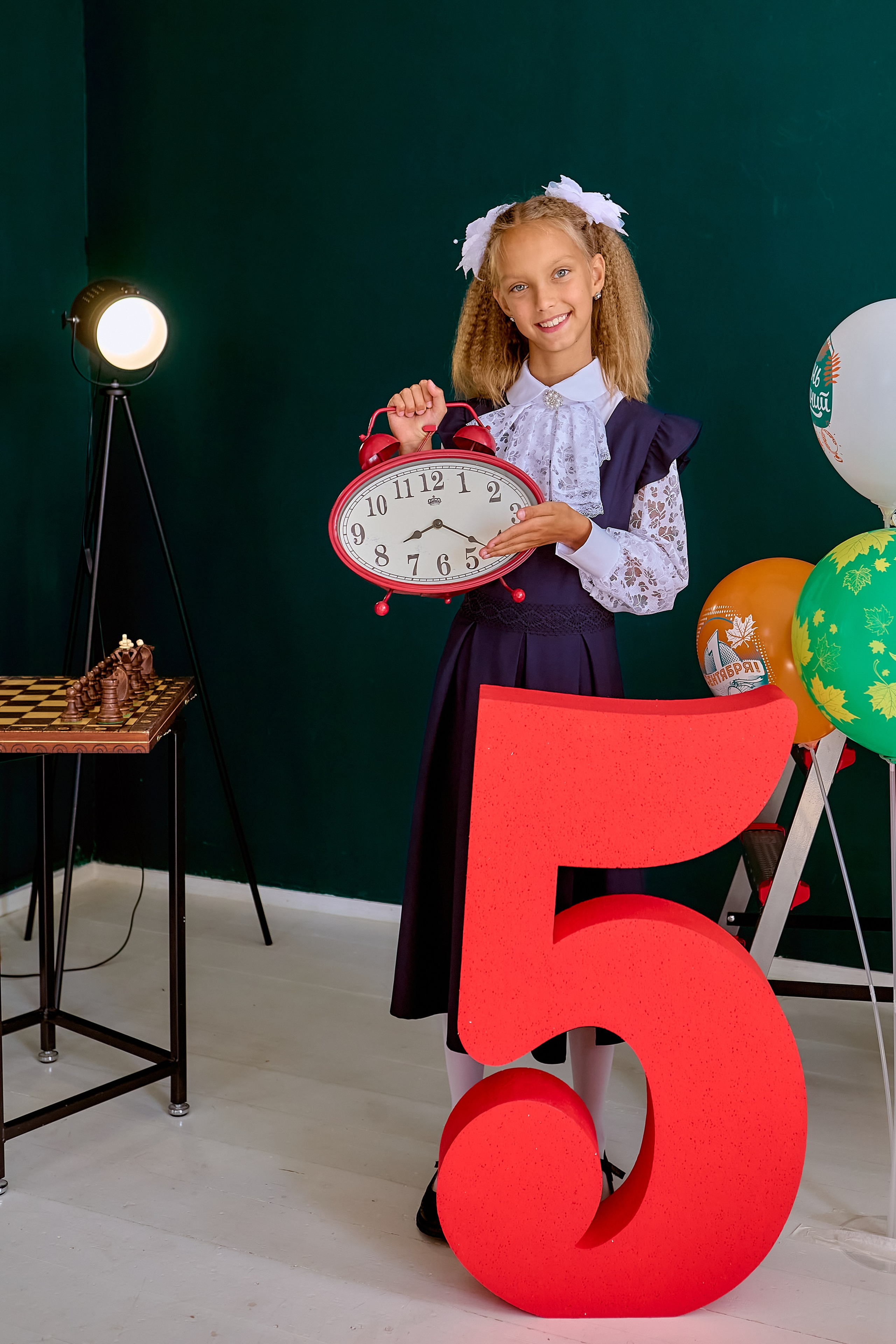 Ростовой портрет. Девочка у цифры пять с будильником в руках. Фотограф Николай Голованов г. Дзержинск