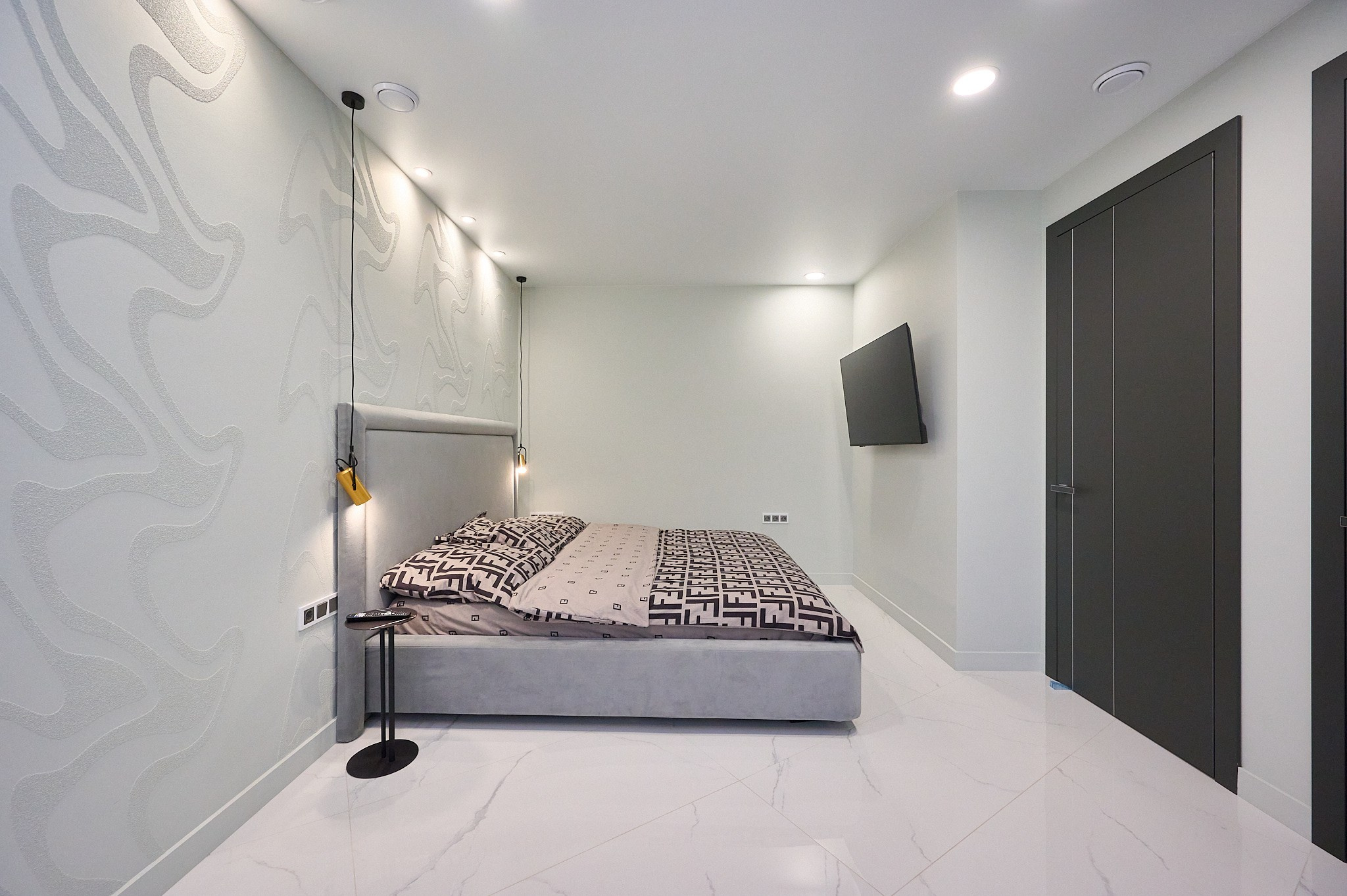 комната серые стены серая кровать телевизор