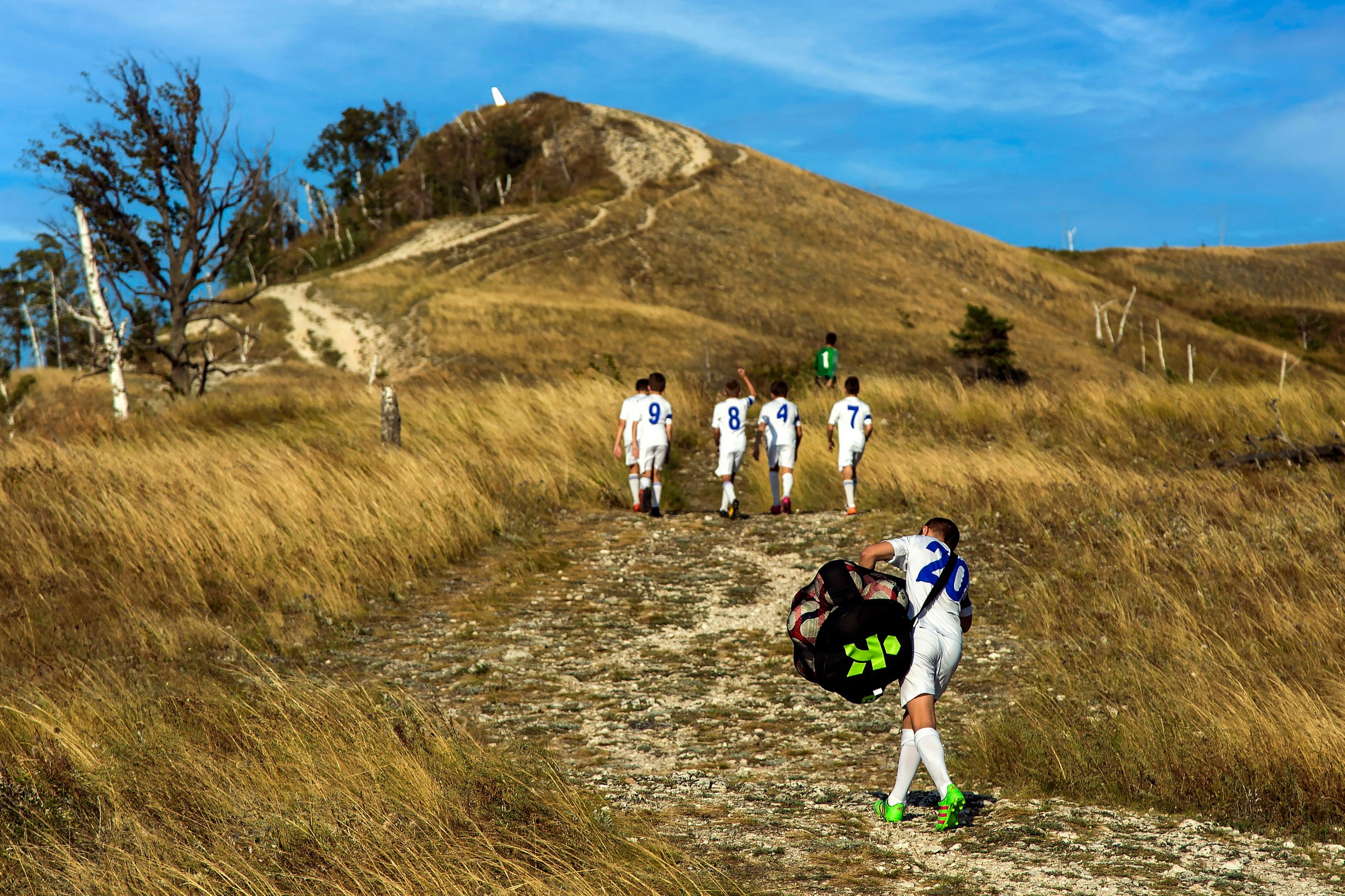 спортивная фотография, юные футболисты идут в гору, футбол