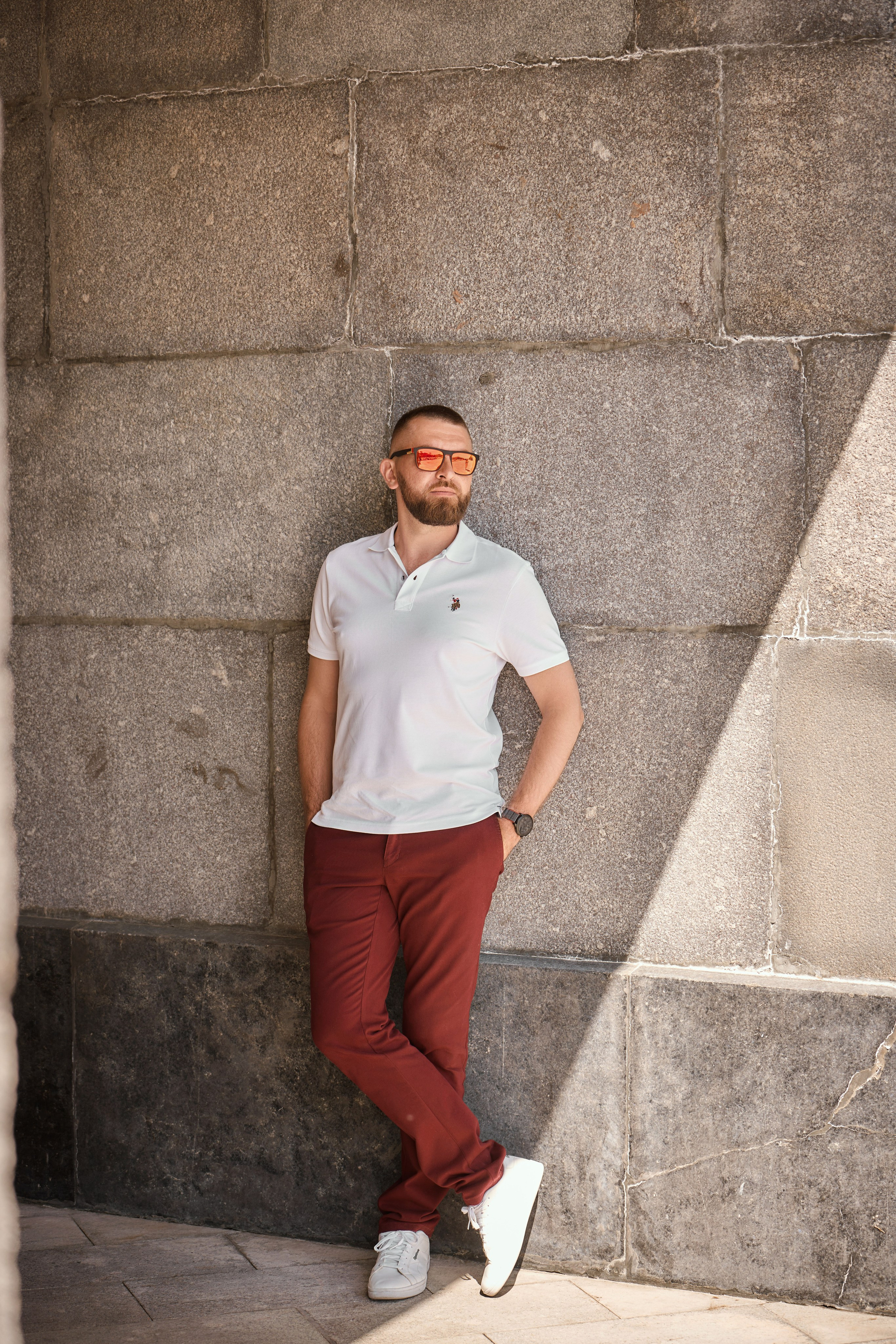 мужчина в красных штанах облокотился на стену