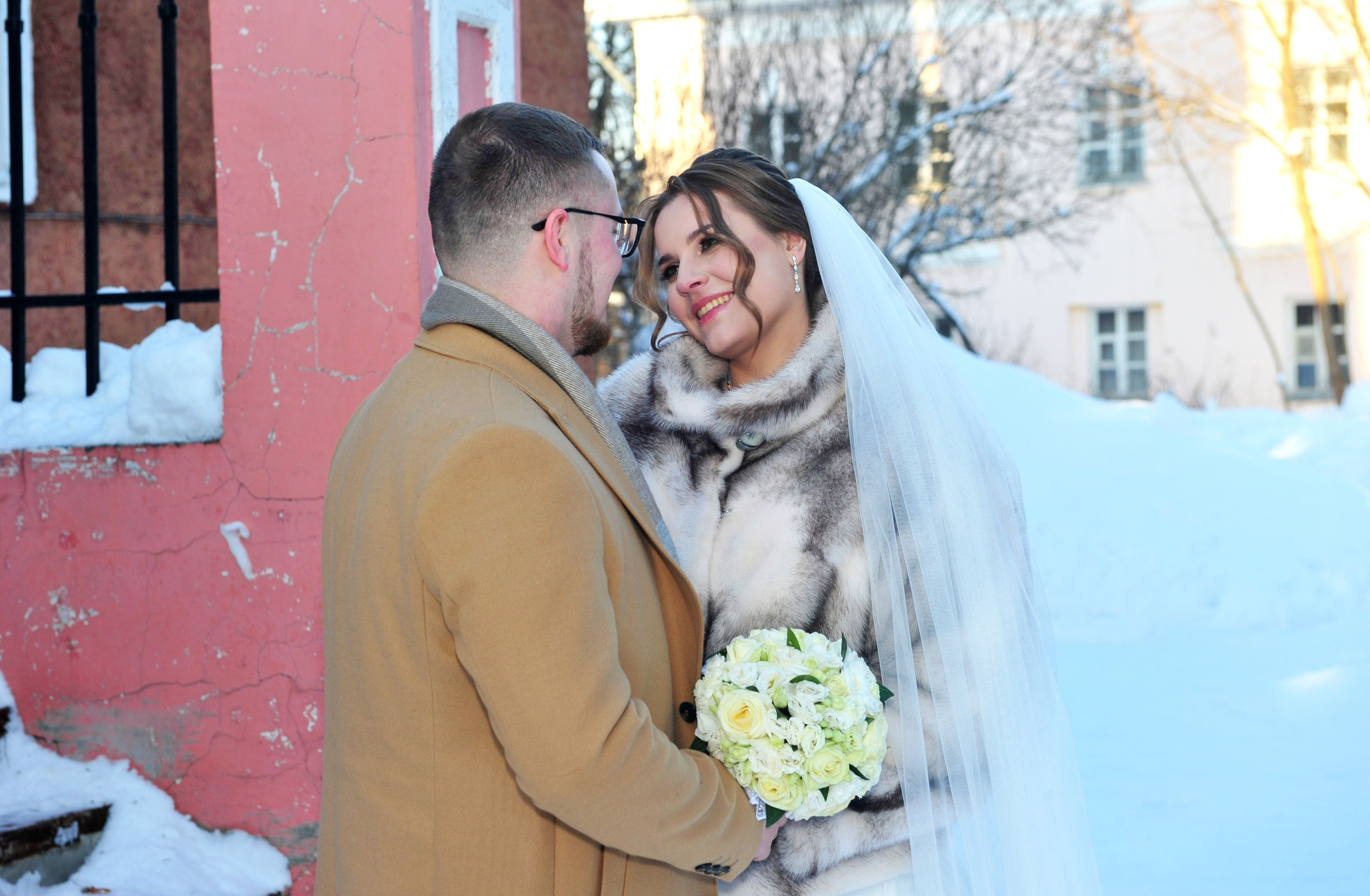 Зимняя свадьба в усадьбе Суханово, свадьба в мороз, молодожены смотрят друг на друга на фоне потрескавшейся стены