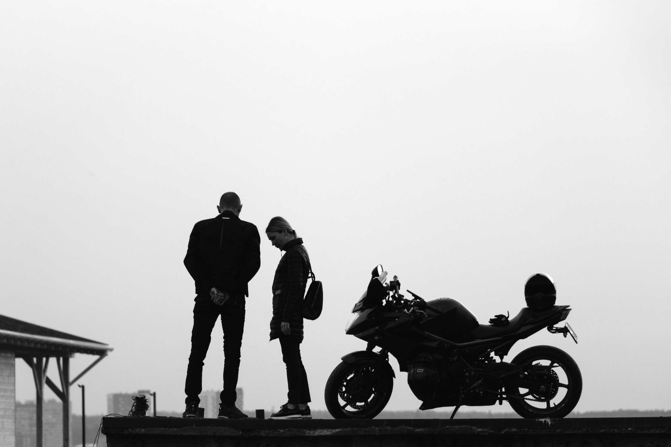 Парочка и мотоцикл стоят на старом городском пирсе