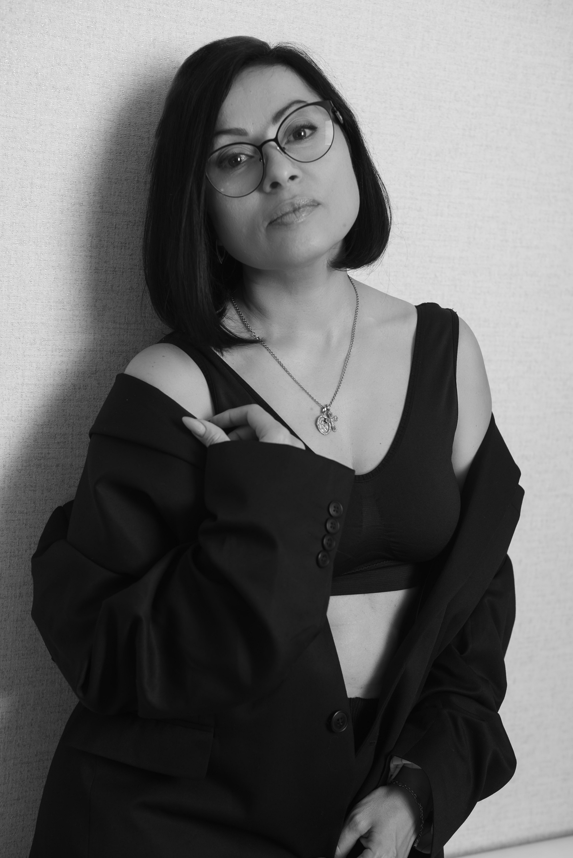 Задумчивая девушка стоит у стены.