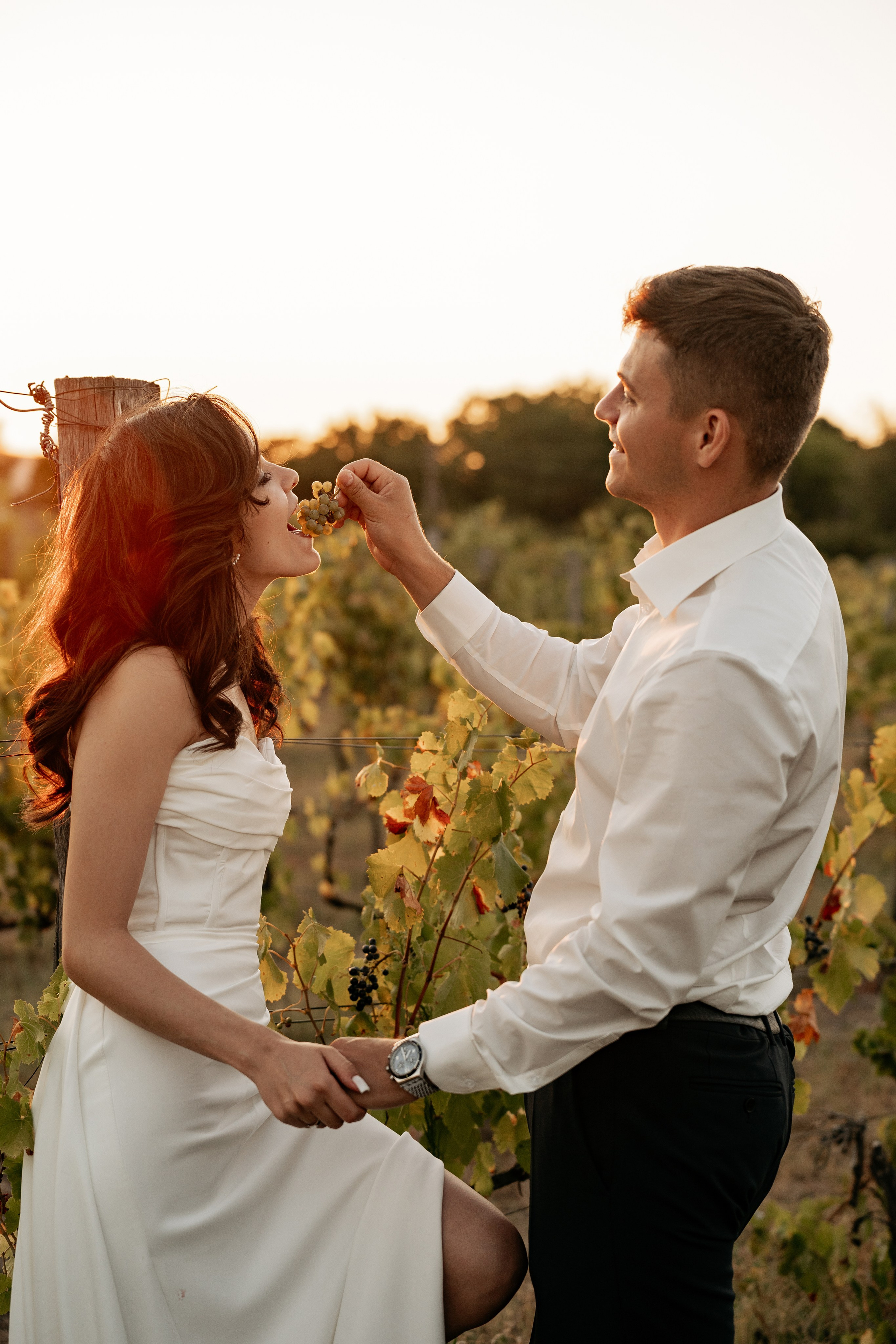Свадебная фотосессия в усадьбе Семигорье, жених кормит невесту виноградом. 